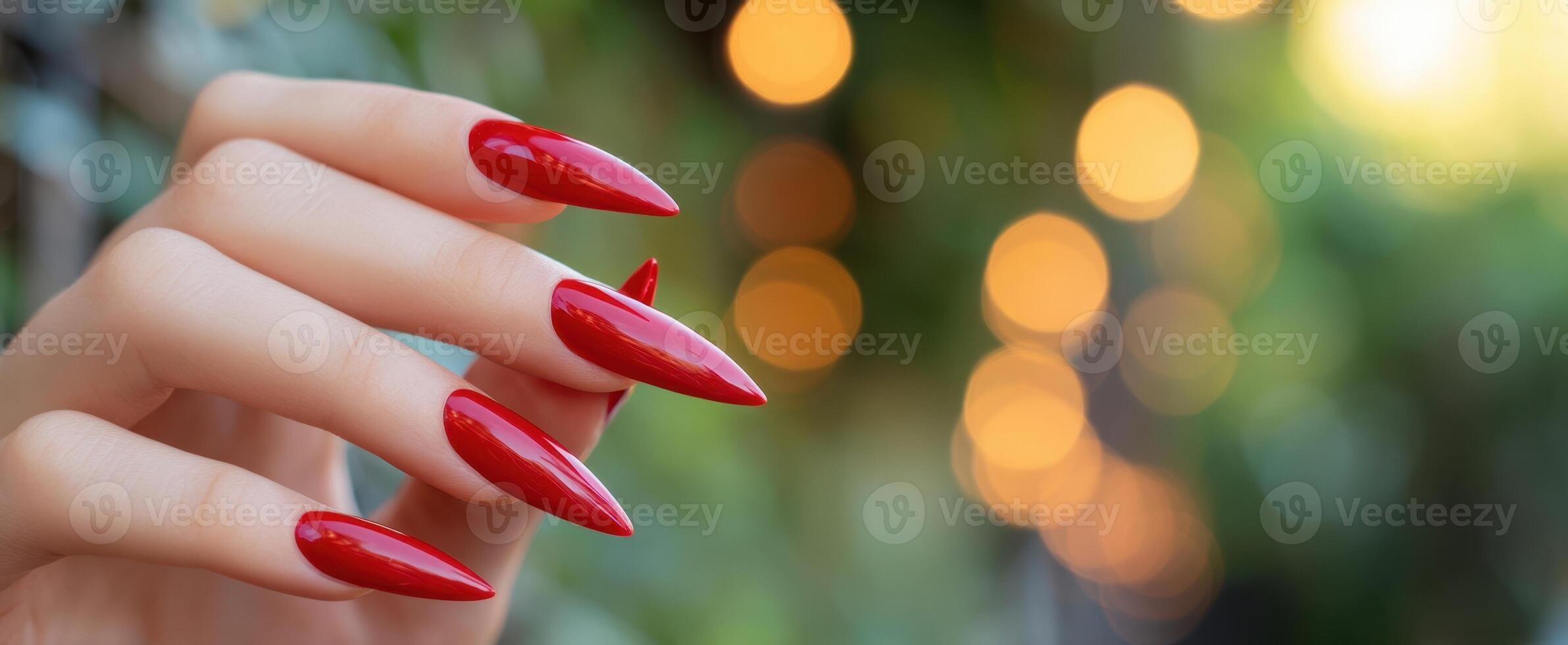 The elegant hand showcasing striking red manicure with bokeh background. photo