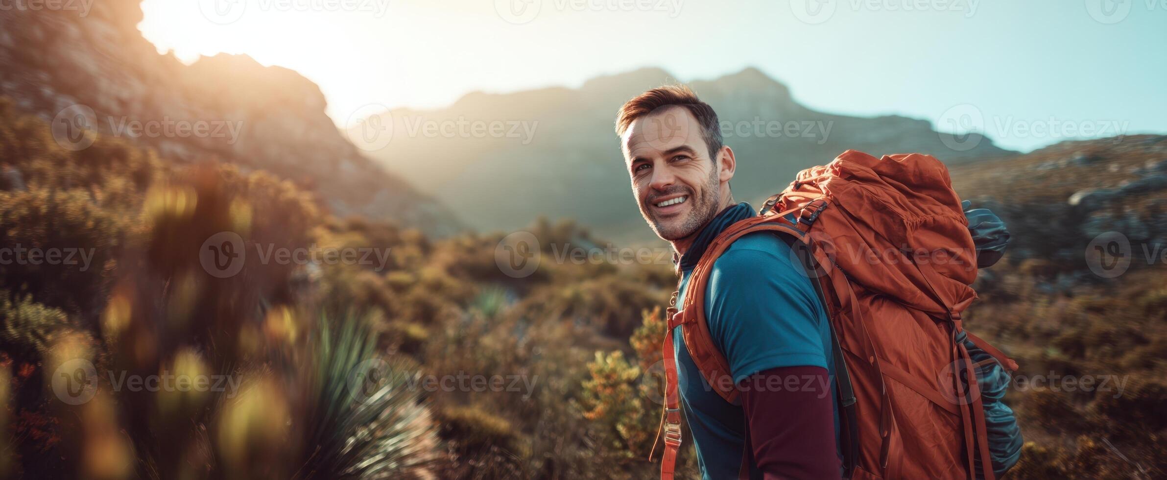 The smiling hiker enjoying a breathtaking mountain adventure at sunrise. photo