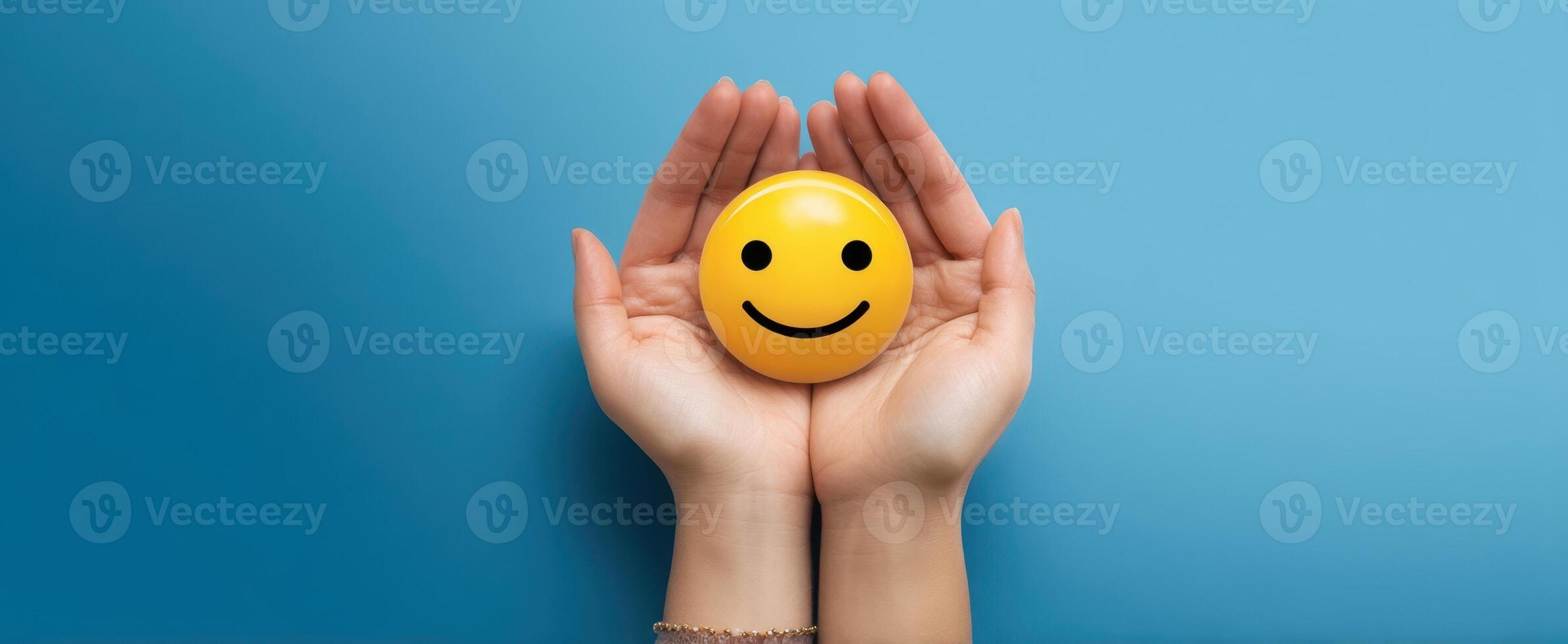 The hands holding a cheerful smiley face symbolizing positivity and joy. photo