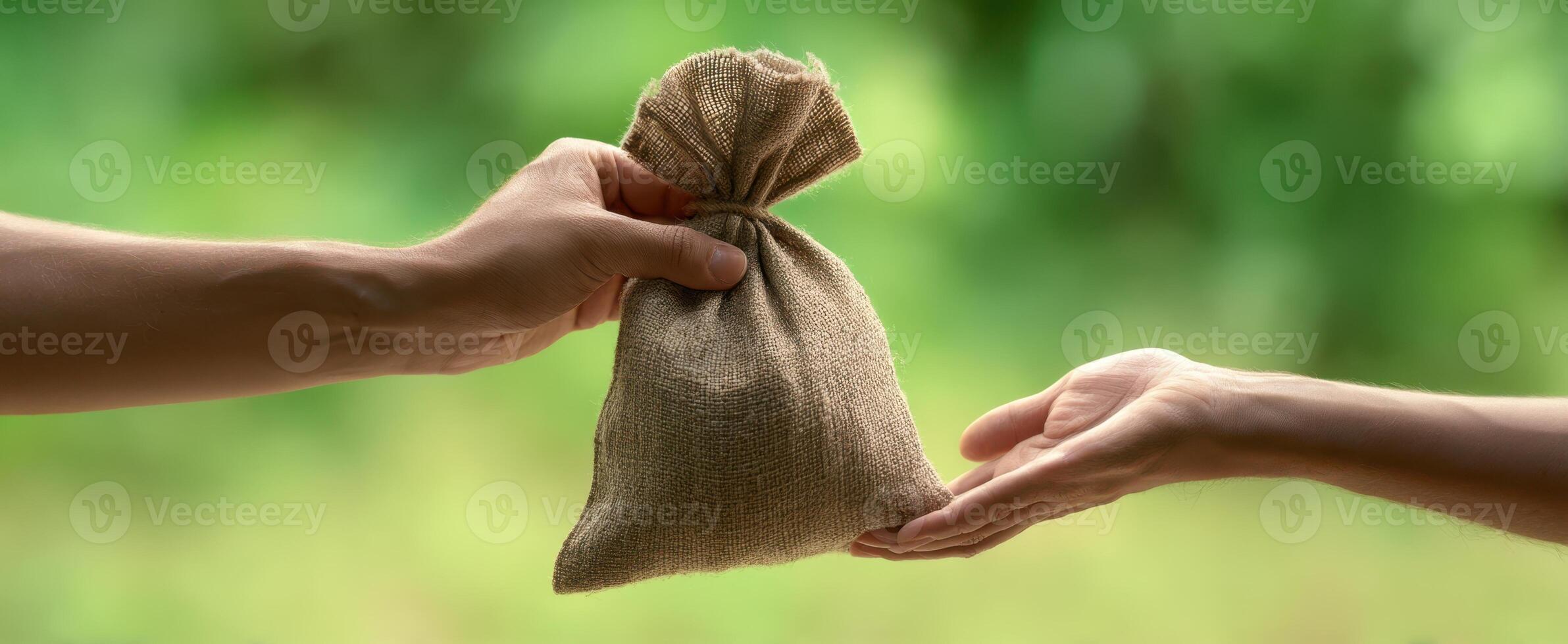 The hands exchanging a small burlap bag filled with valuable contents. photo