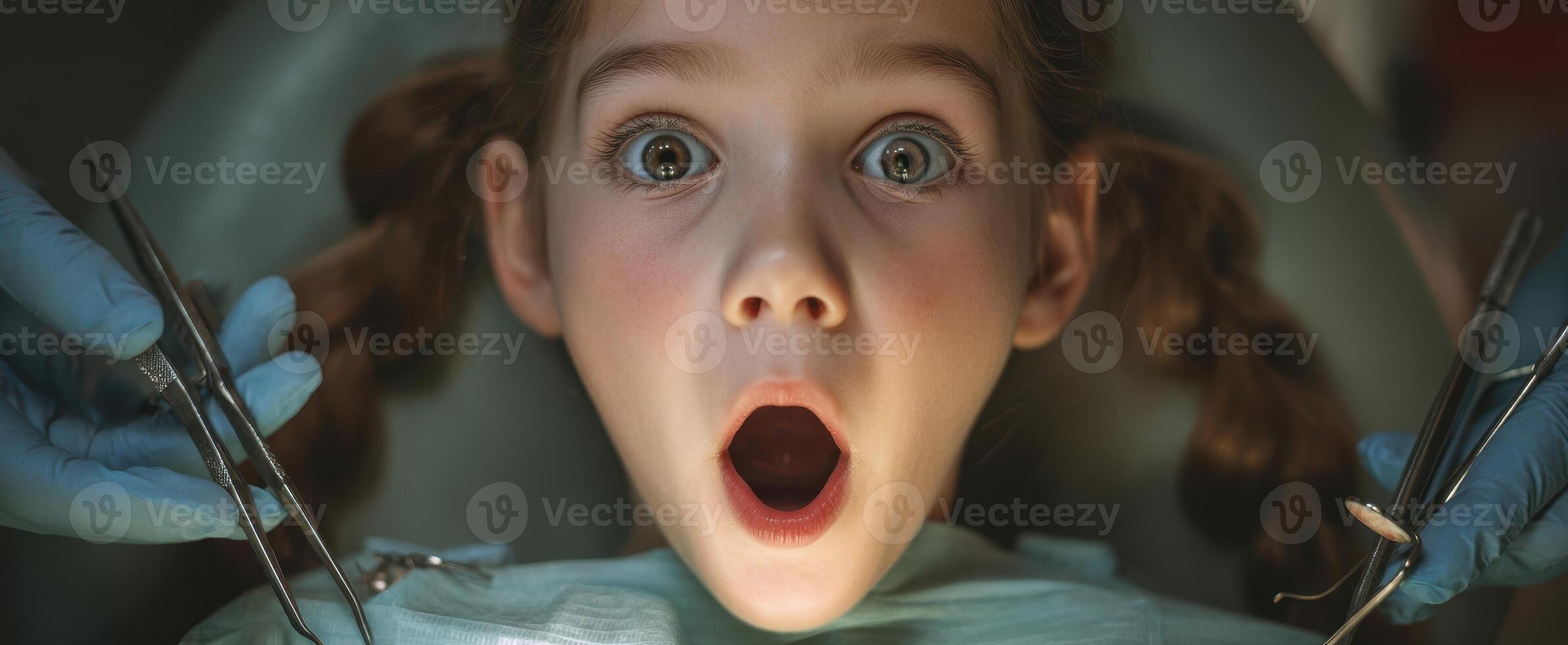 The shocked girl experiencing a dental procedure with wide eyes and open mouth. photo