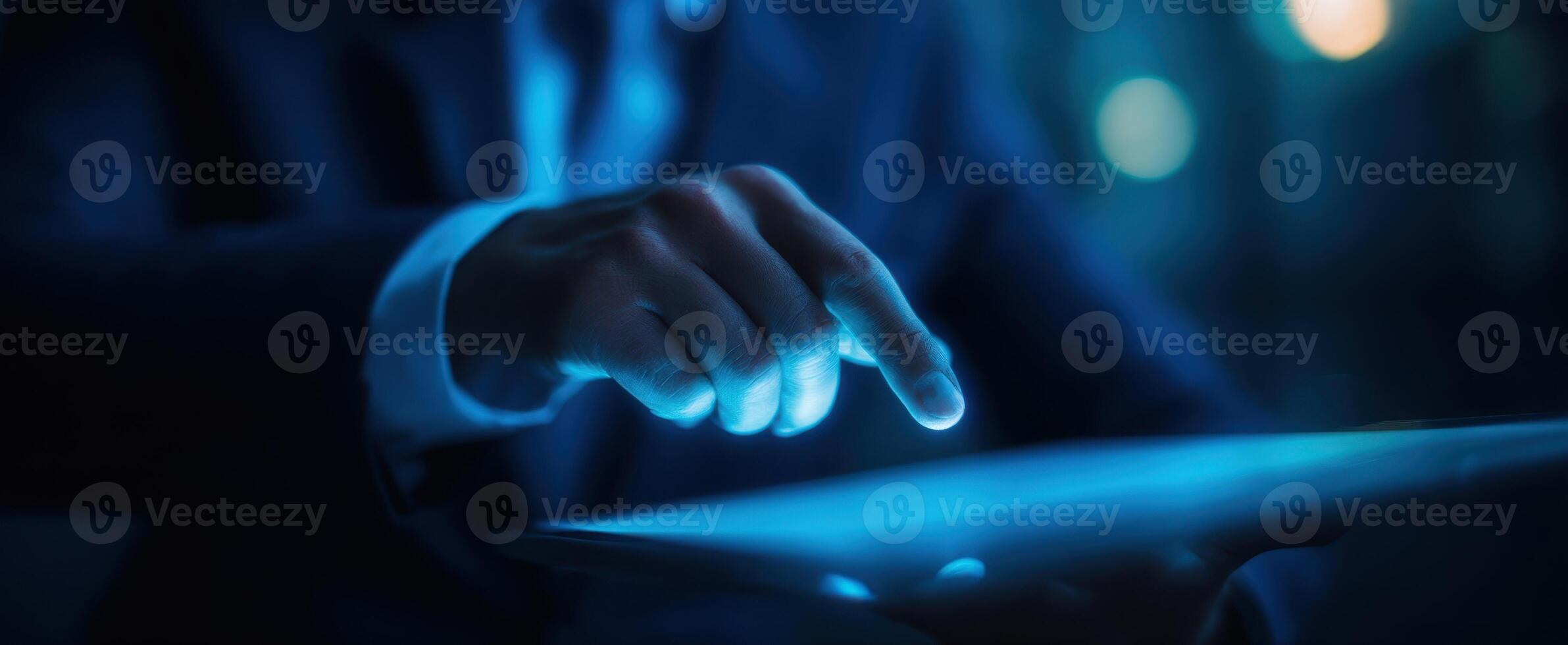 The businessman interacting with a glowing tablet screen in a modern environment. photo