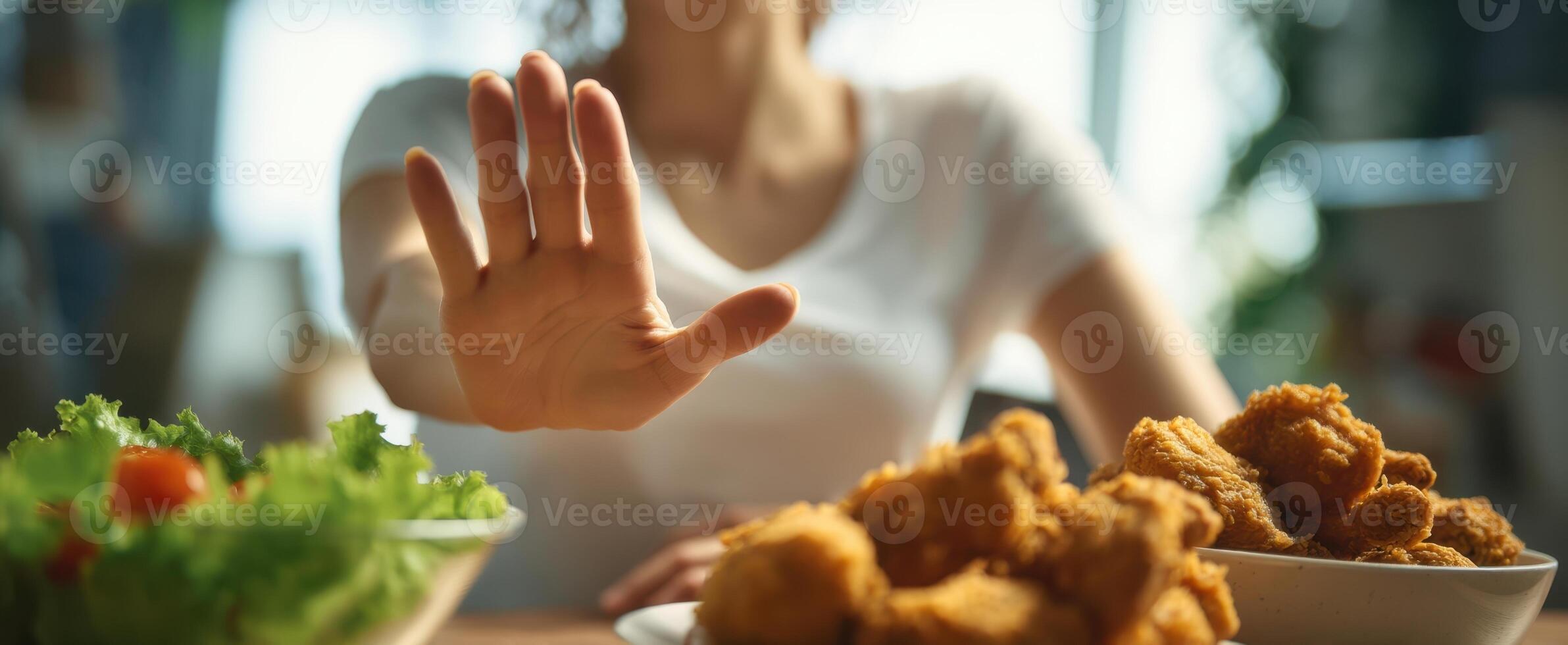 The woman refusing fried chicken in favor of a healthy salad choice. photo