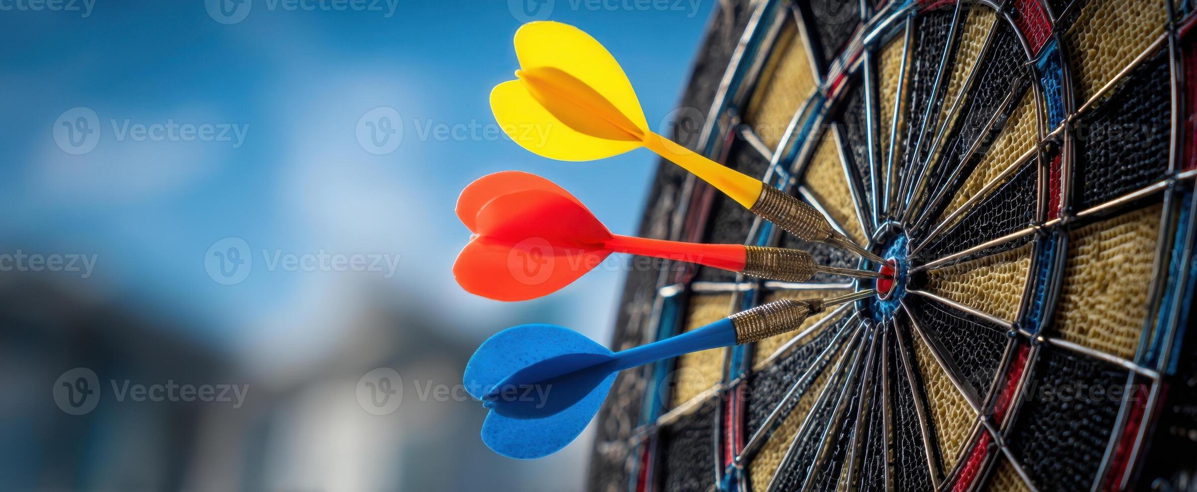 The colorful darts striking perfectly on a dartboard in bright outdoor setting photo