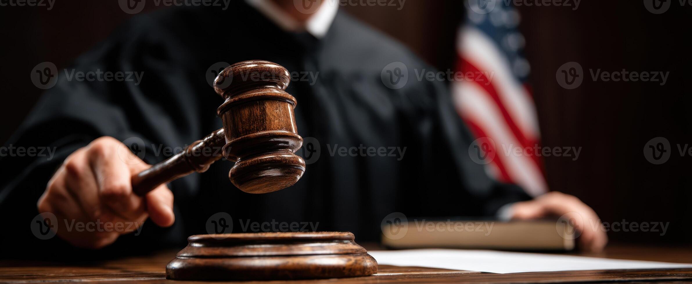 The judge holding a gavel in a formal courtroom setting. photo