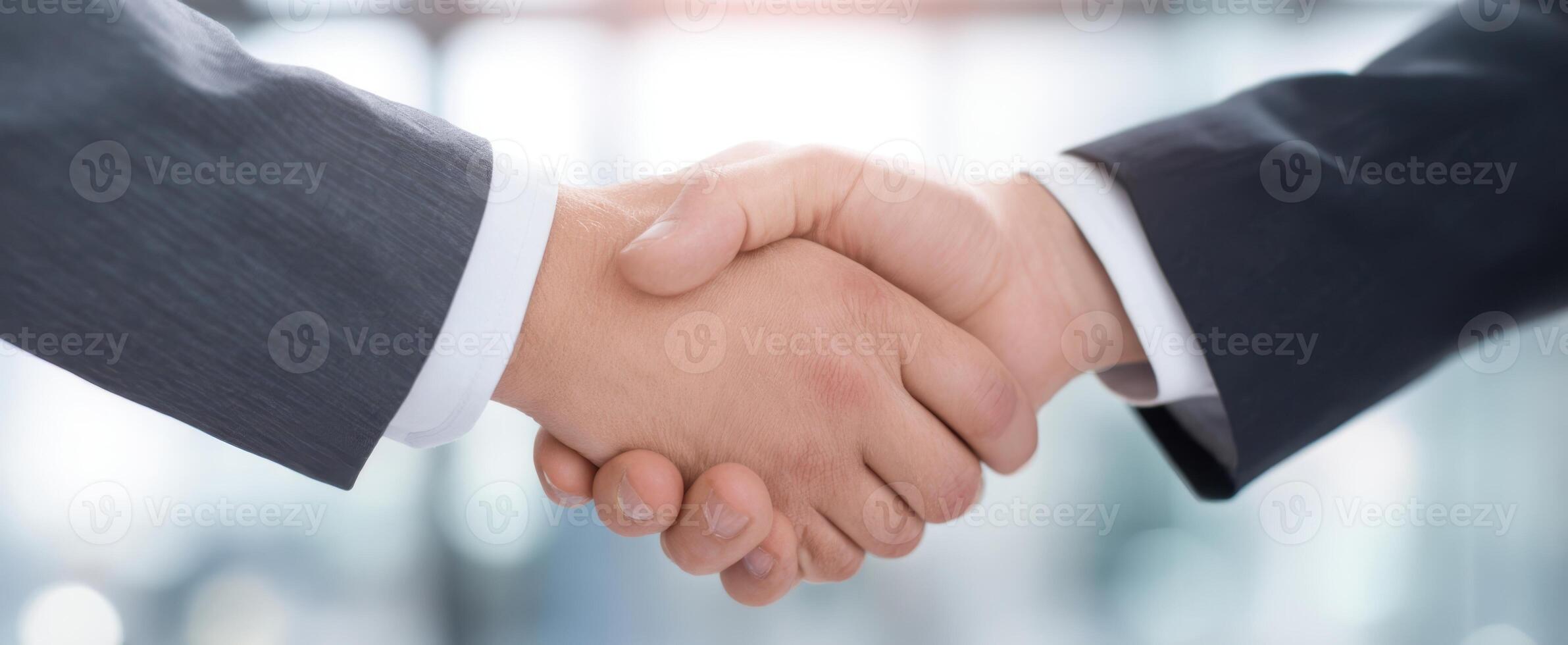 Business people shaking hands over blurred background photo