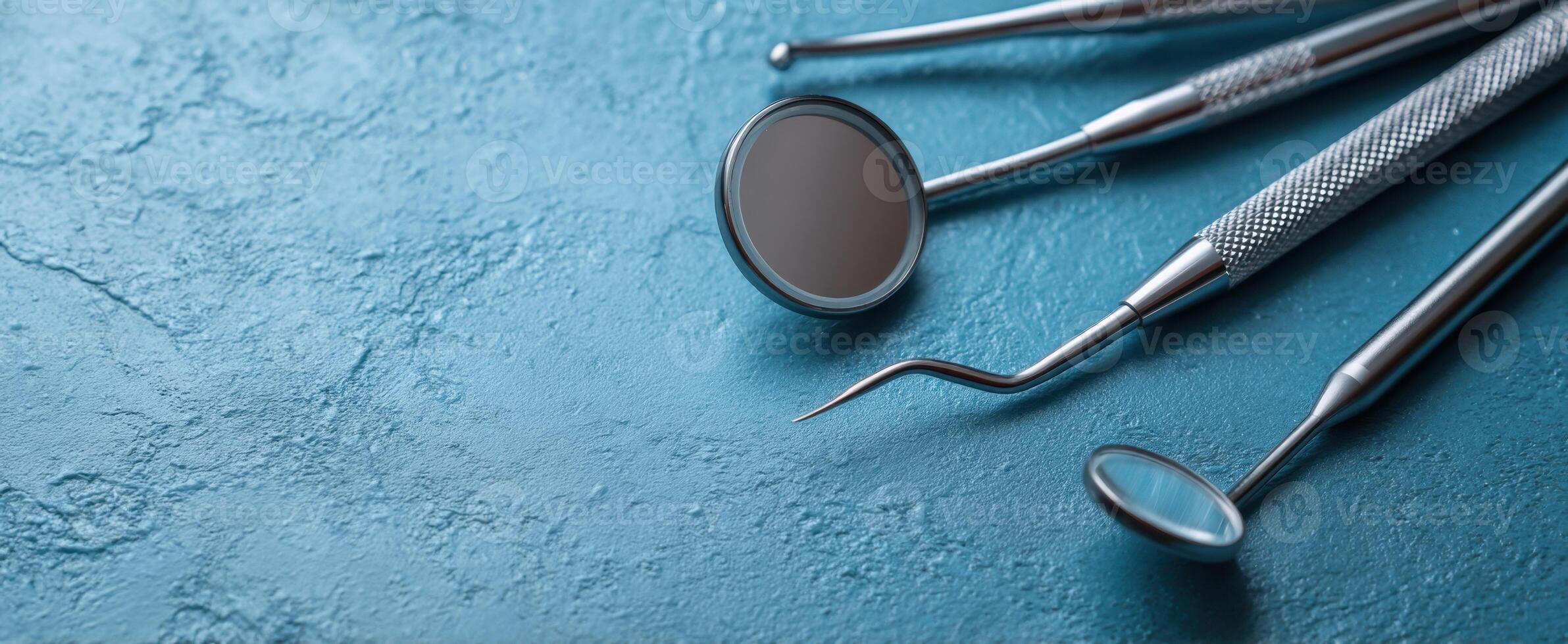 The dental instruments arranged on a blue textured background for healthcare. photo