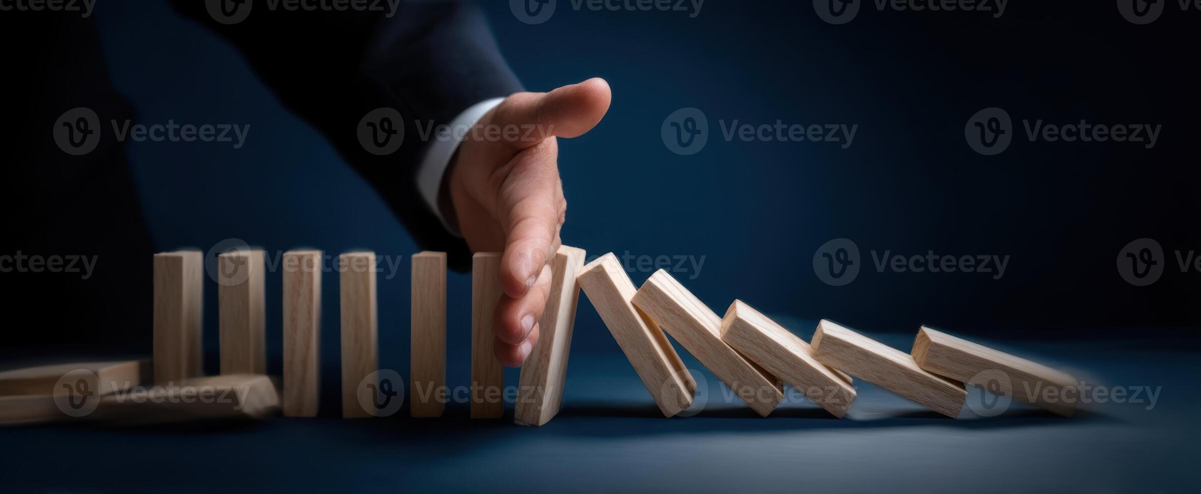 The hand preventing dominoes from falling in a strategic business decision-making moment. photo