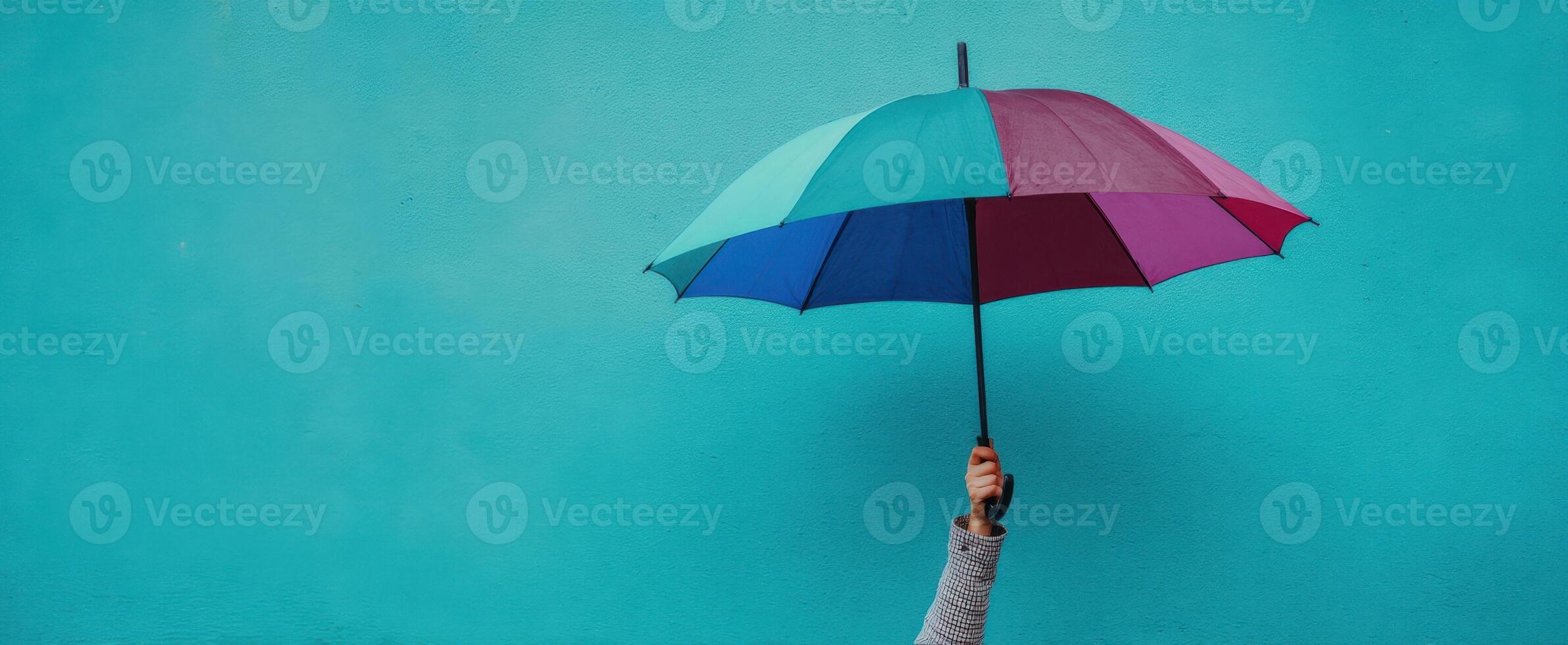 The colorful umbrella against a vibrant blue wall showcasing joy and protection. photo