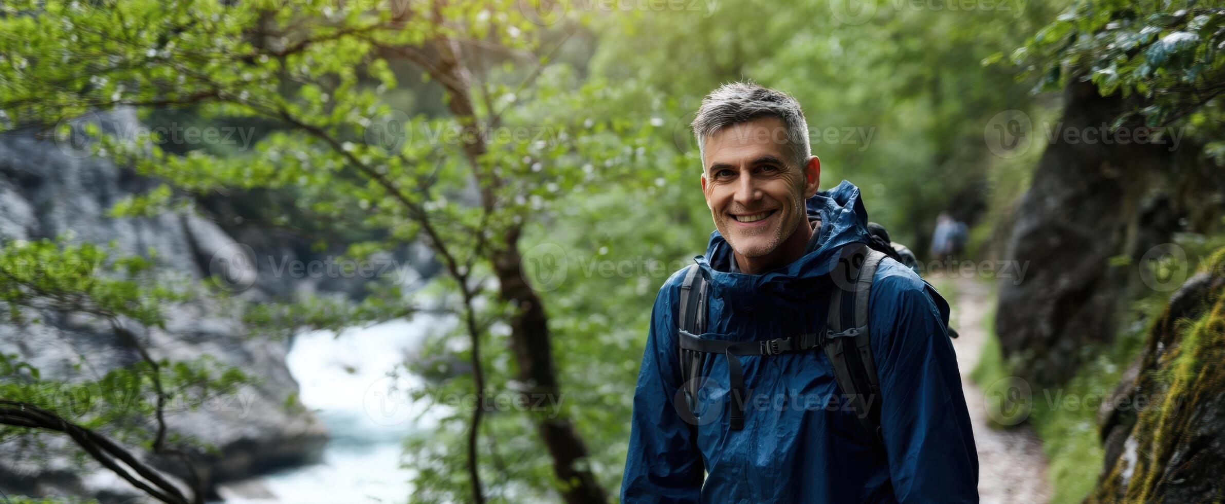 The joyful hiker enjoying nature by a scenic river in the forest. photo
