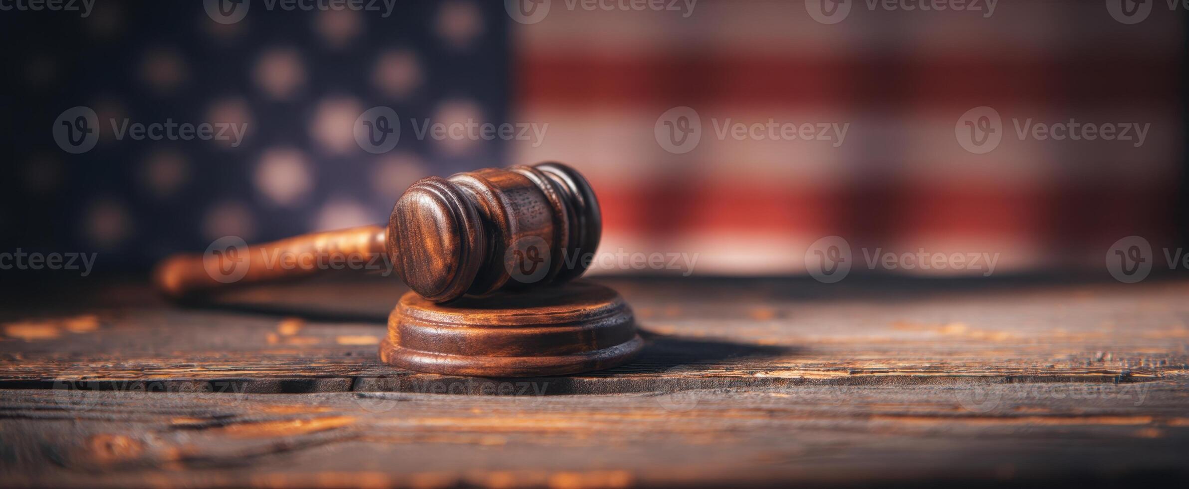The gavel symbolizing justice set against a blurred American flag background. photo