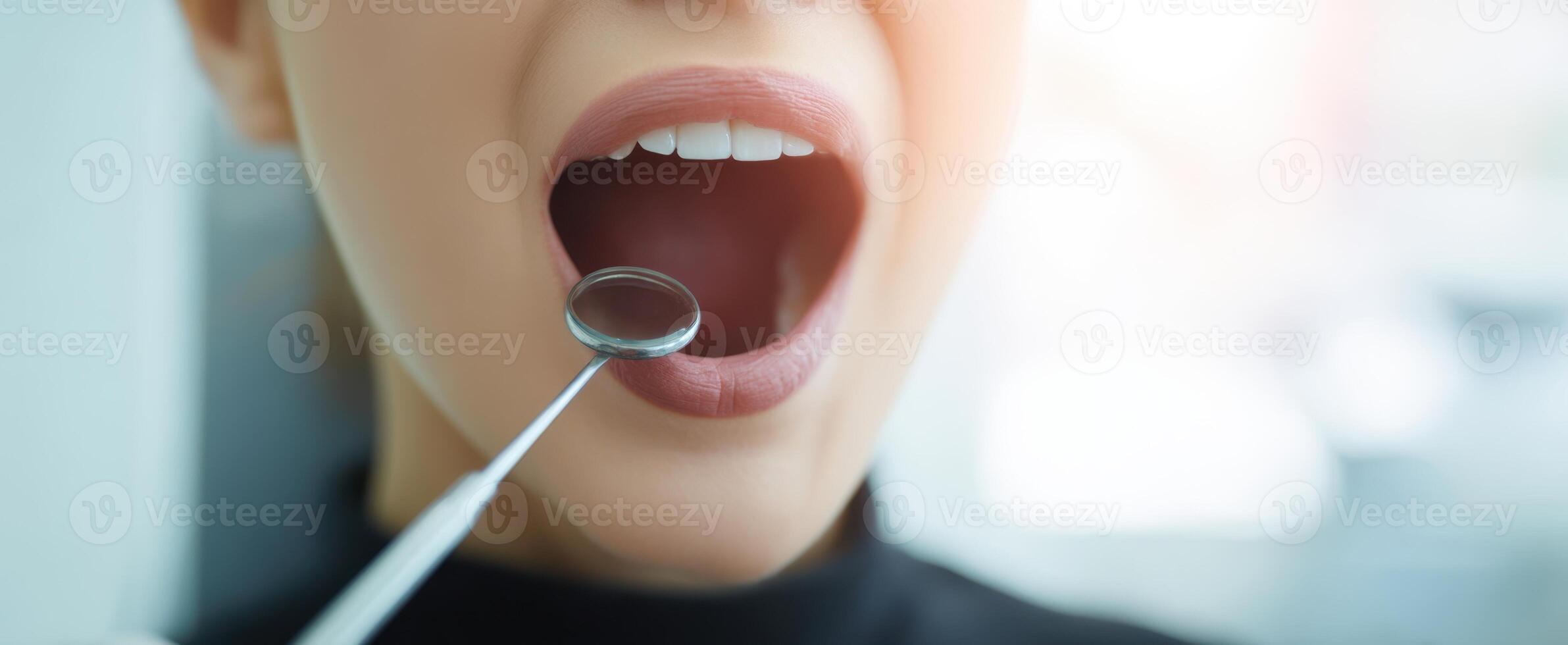 The woman in dental examination with open mouth and professional tools. photo