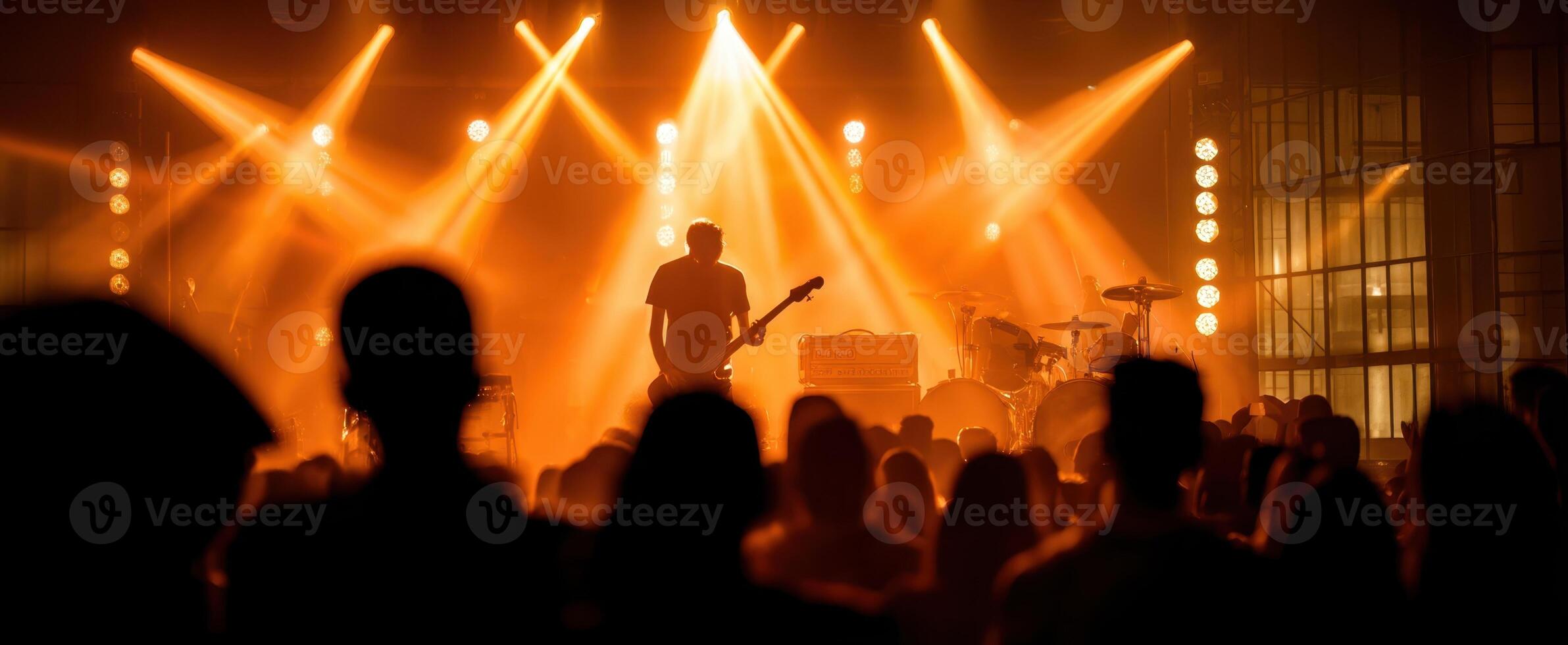 The guitarist shines under vibrant lights at a live music concert. photo
