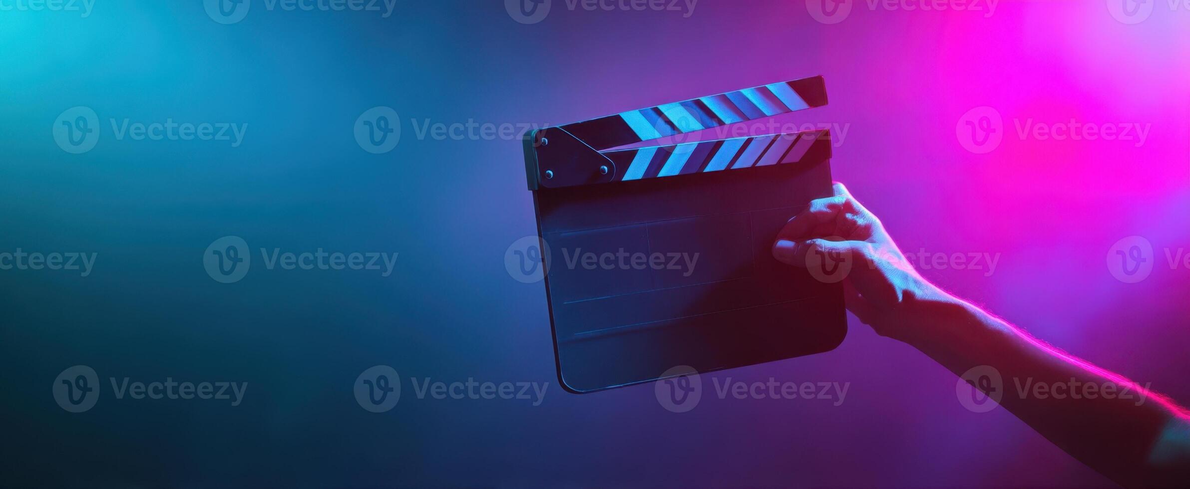 The clapperboard held in a colorful light atmosphere for filmmaking creativity. photo
