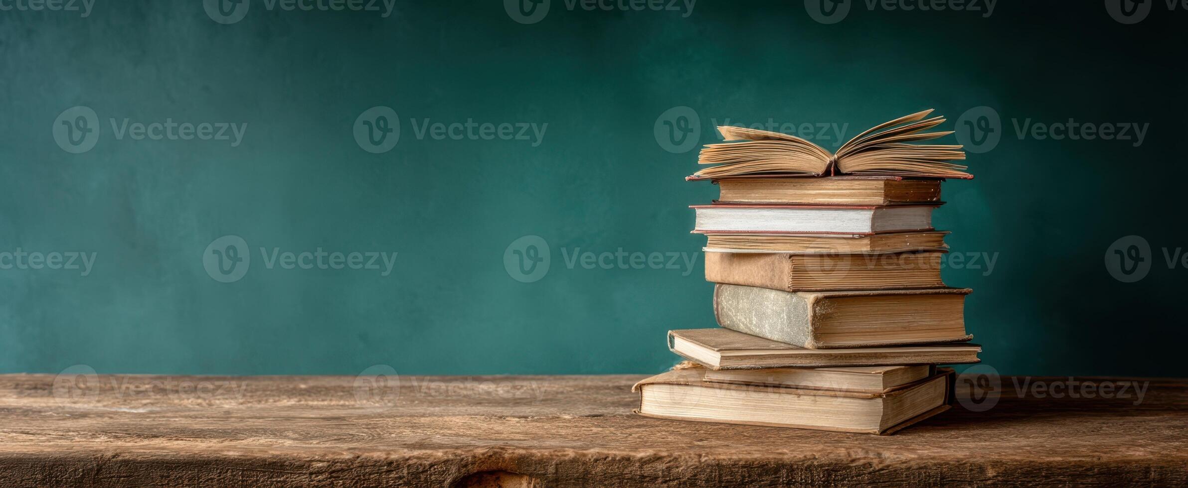 The captivating stack of books on a rustic wooden table in a serene setting. photo