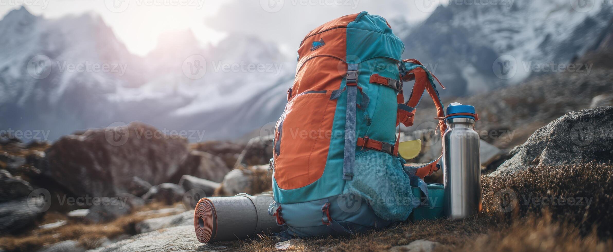 The vibrant backpack set against majestic mountain peaks at sunrise. photo