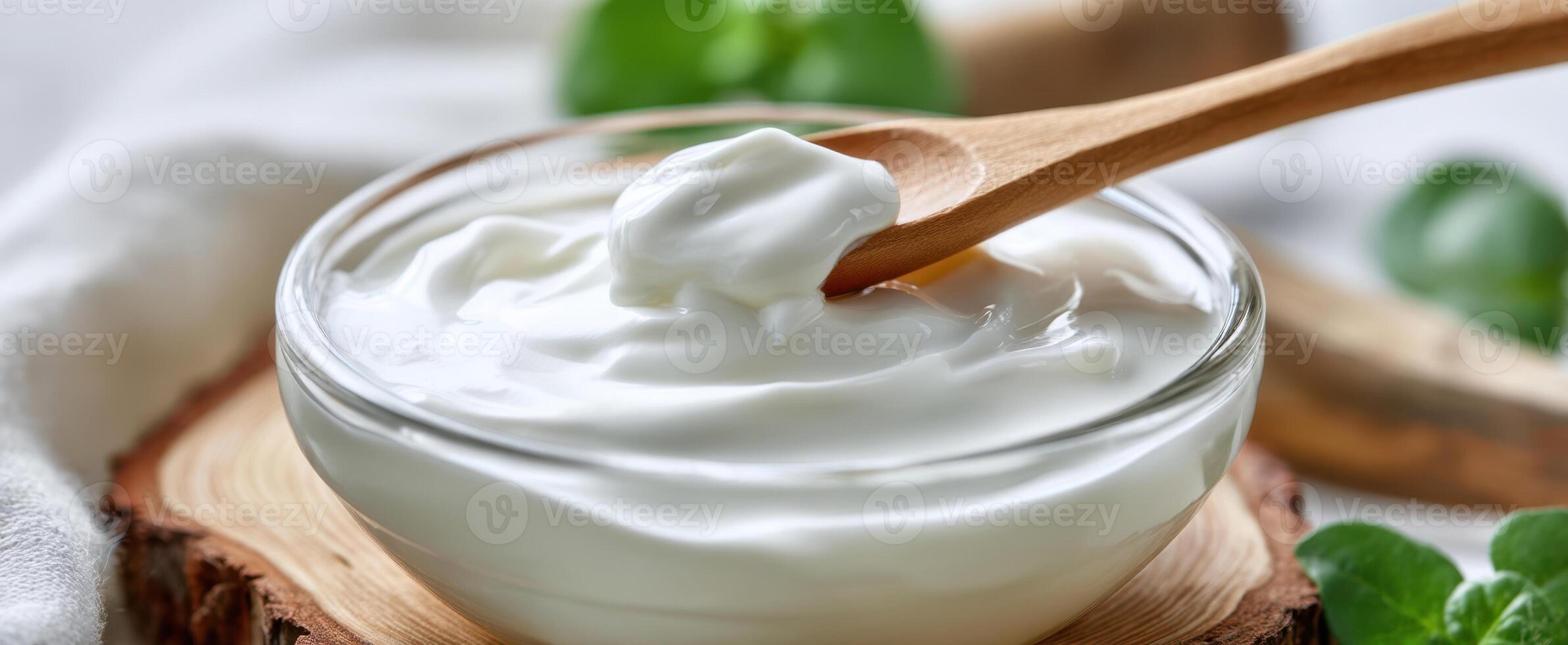 The creamy yogurt in a rustic bowl with a wooden spoon. photo