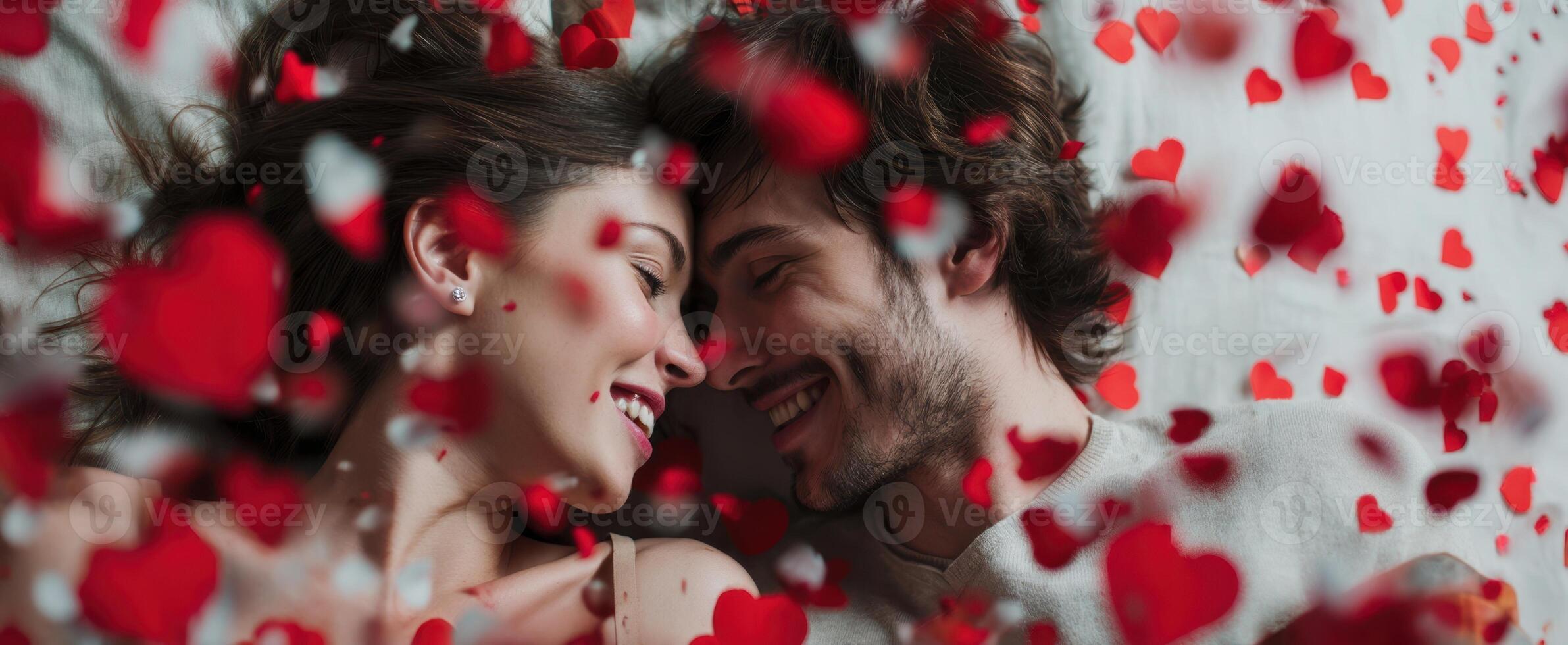The joyful couple surrounded by heart confetti celebrating their love. photo