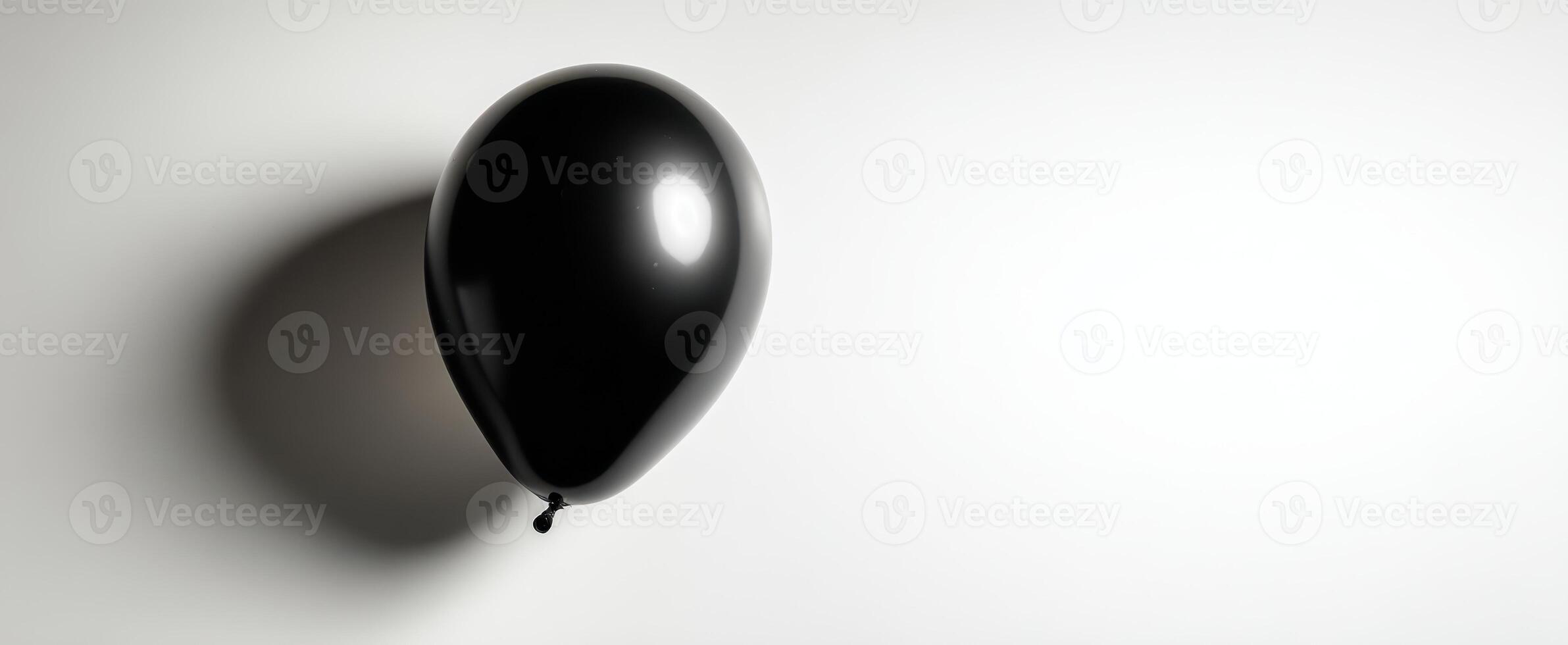 The elegant black balloon casting a soft shadow on a minimalistic background. photo