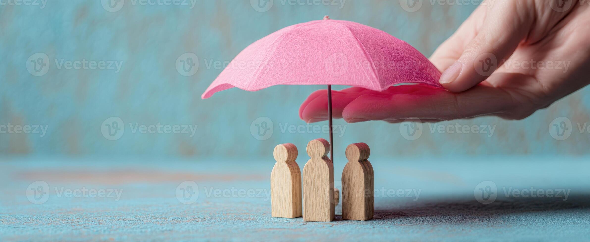The umbrella providing protection to wooden figures representing community and care. photo