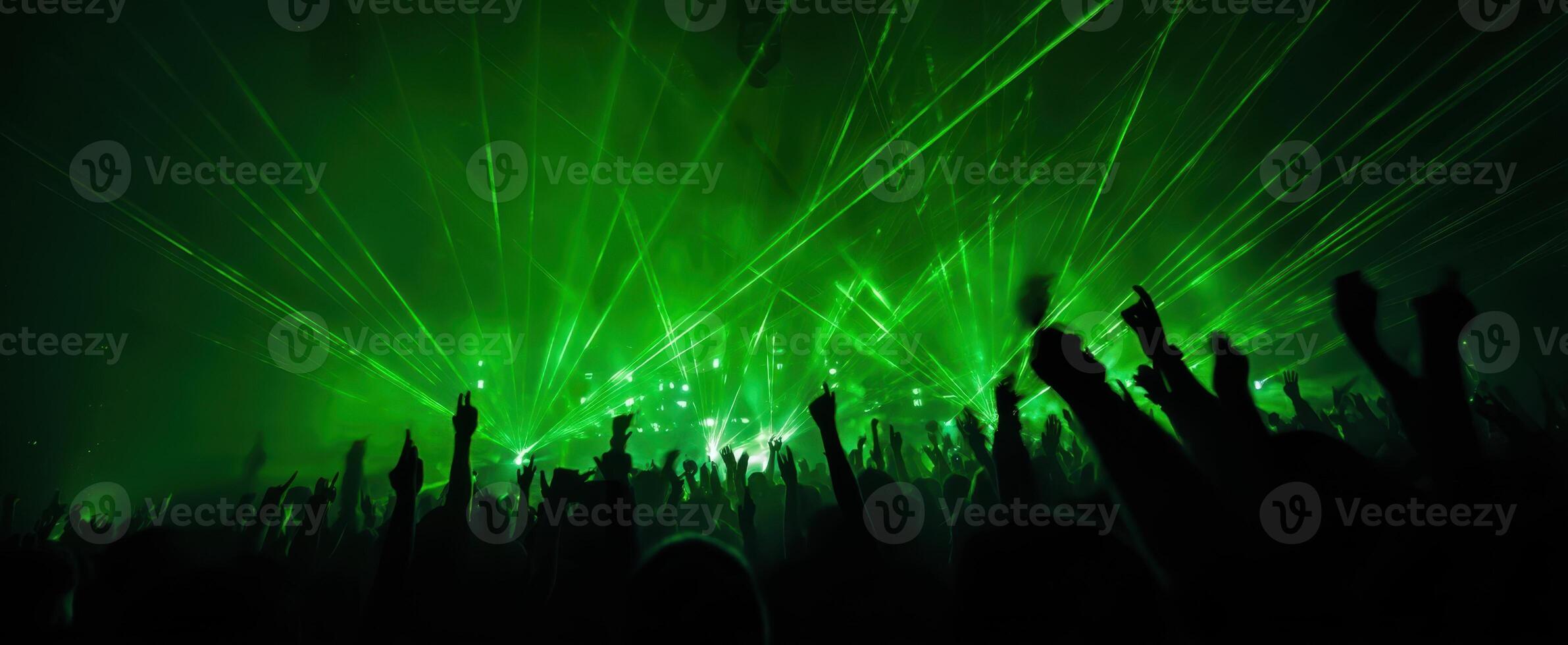 The electric atmosphere of a vibrant crowd at a concert with dazzling lasers. photo