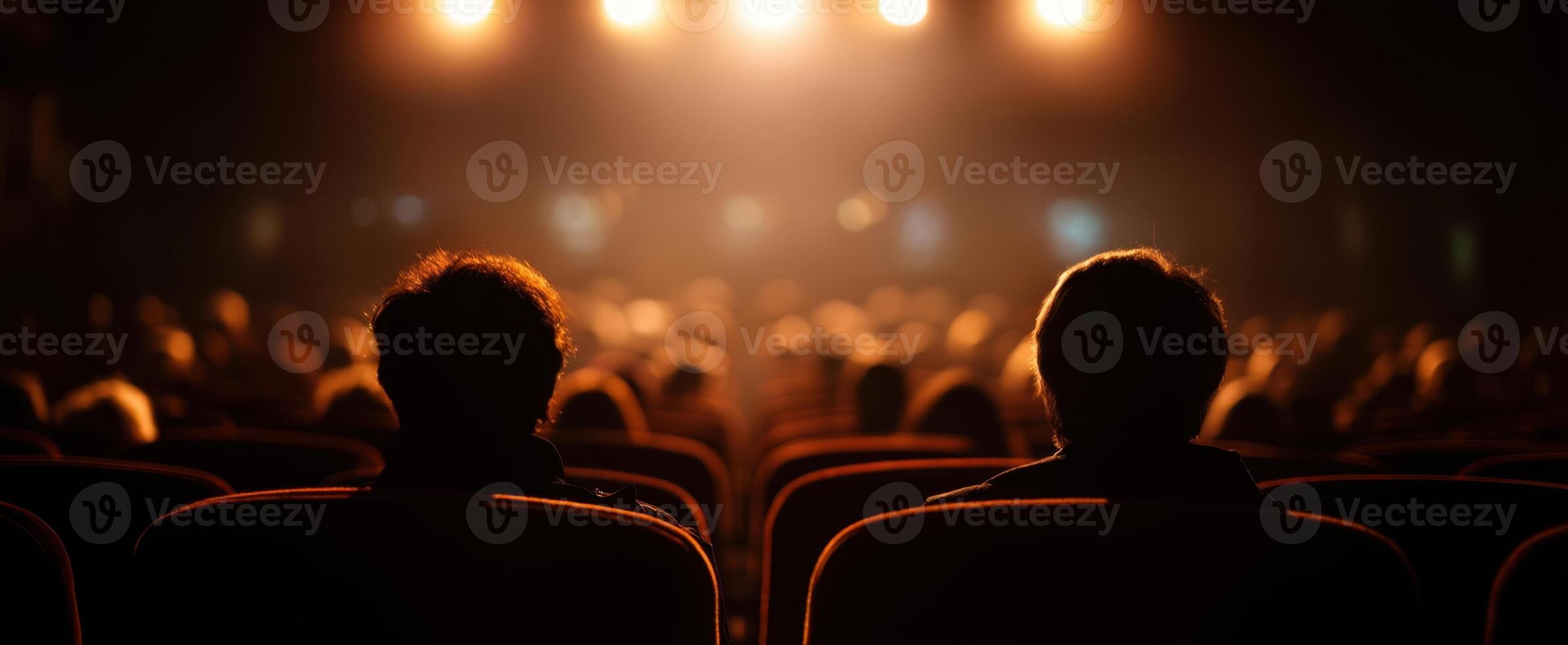 The audience captivated by the performance in a dimly lit theater setting. photo