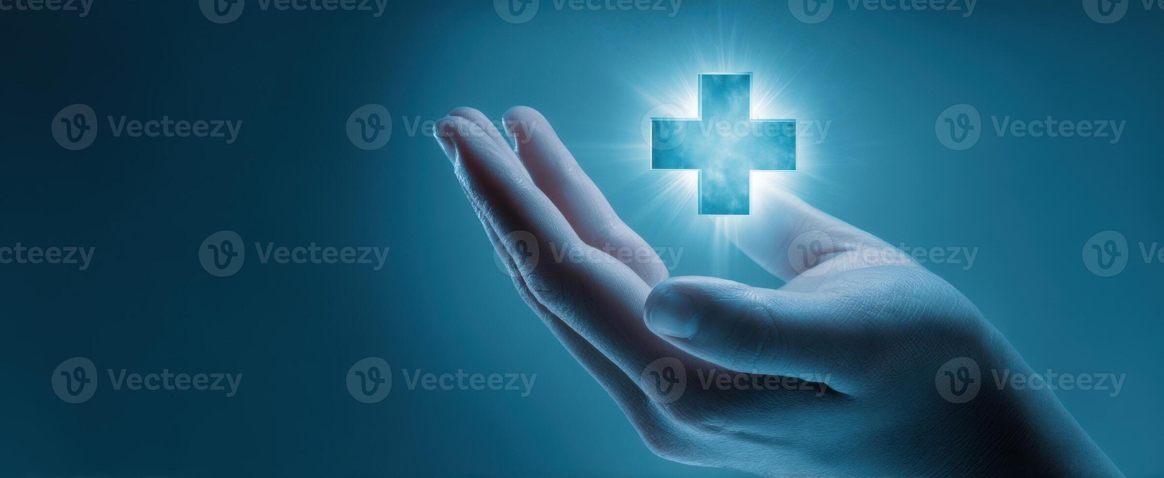 The hand holding a glowing medical cross symbol in a caring gesture. photo