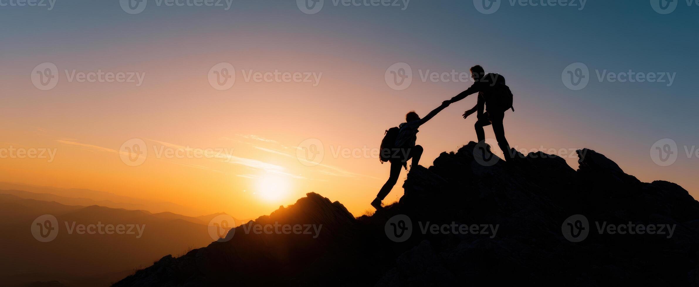 The uplifting moment of two climbers reaching new heights at sunset photo