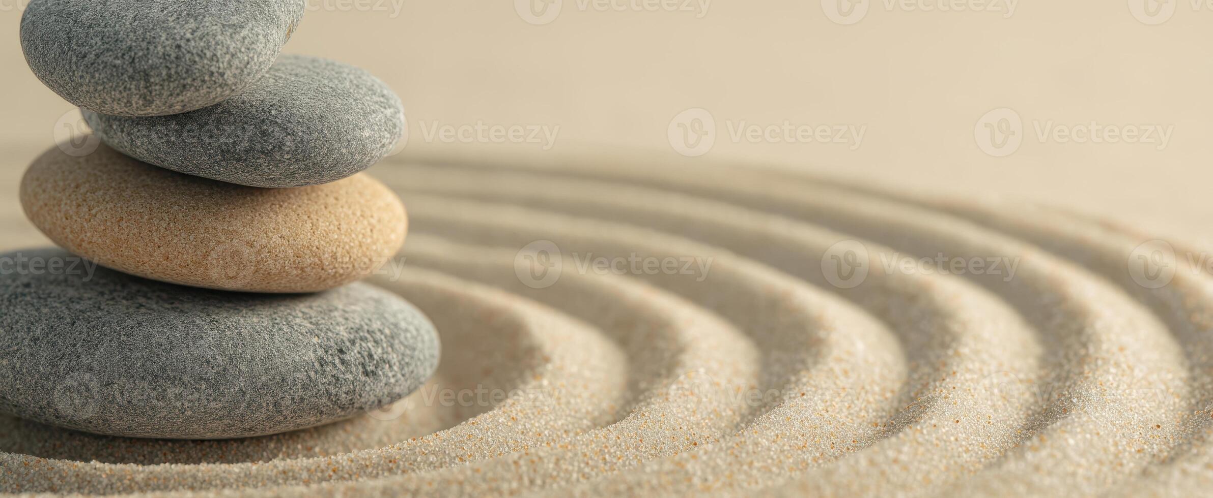 The serene arrangement of stacked stones on calming sand patterns. photo