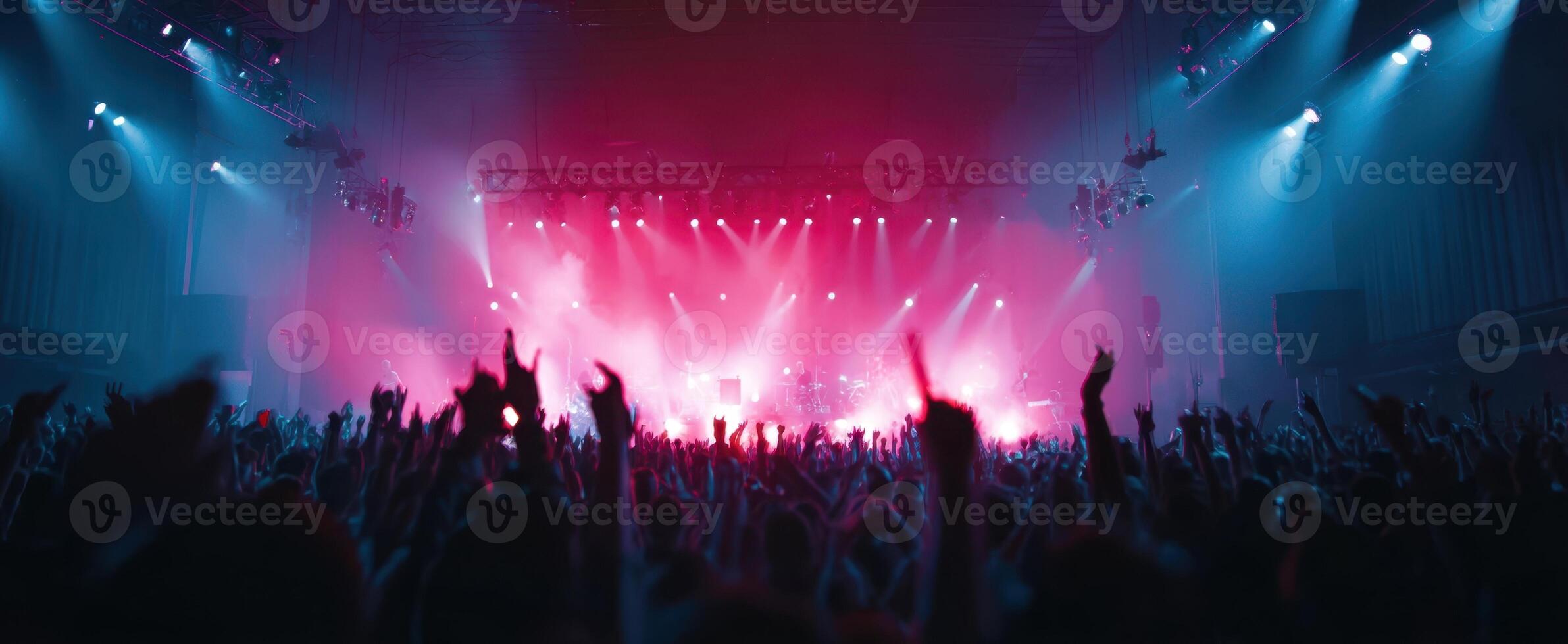 The vibrant concert atmosphere with energetic crowd under colorful lights photo