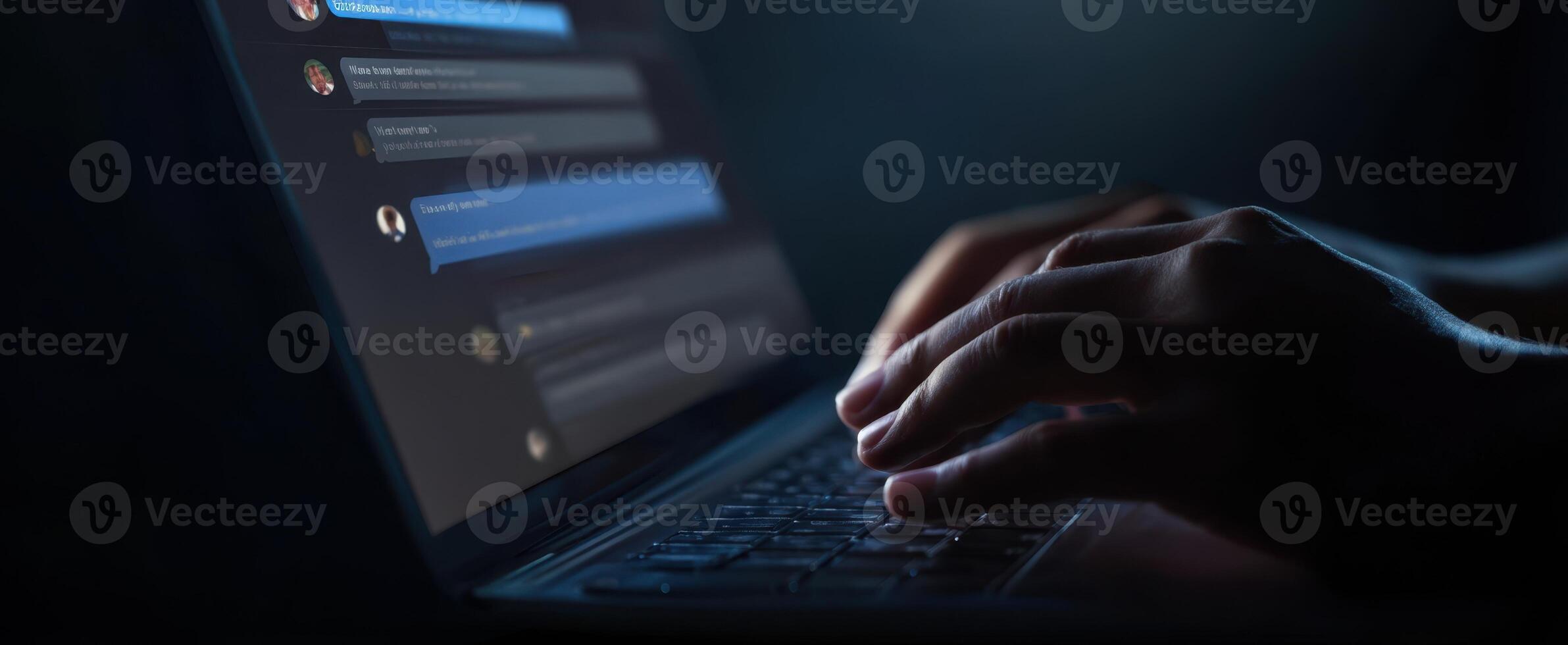 The laptop keyboard illuminated by hands typing in a dark environment. photo