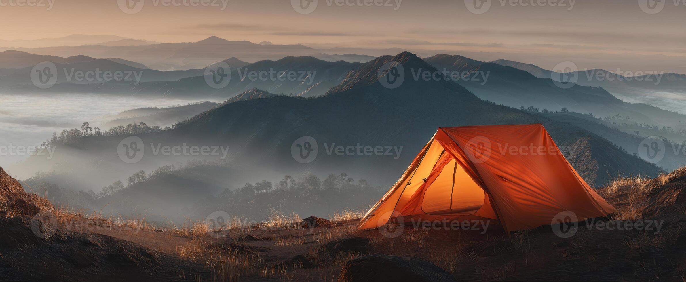 The vibrant orange tent overlooking misty mountains at sunrise photo