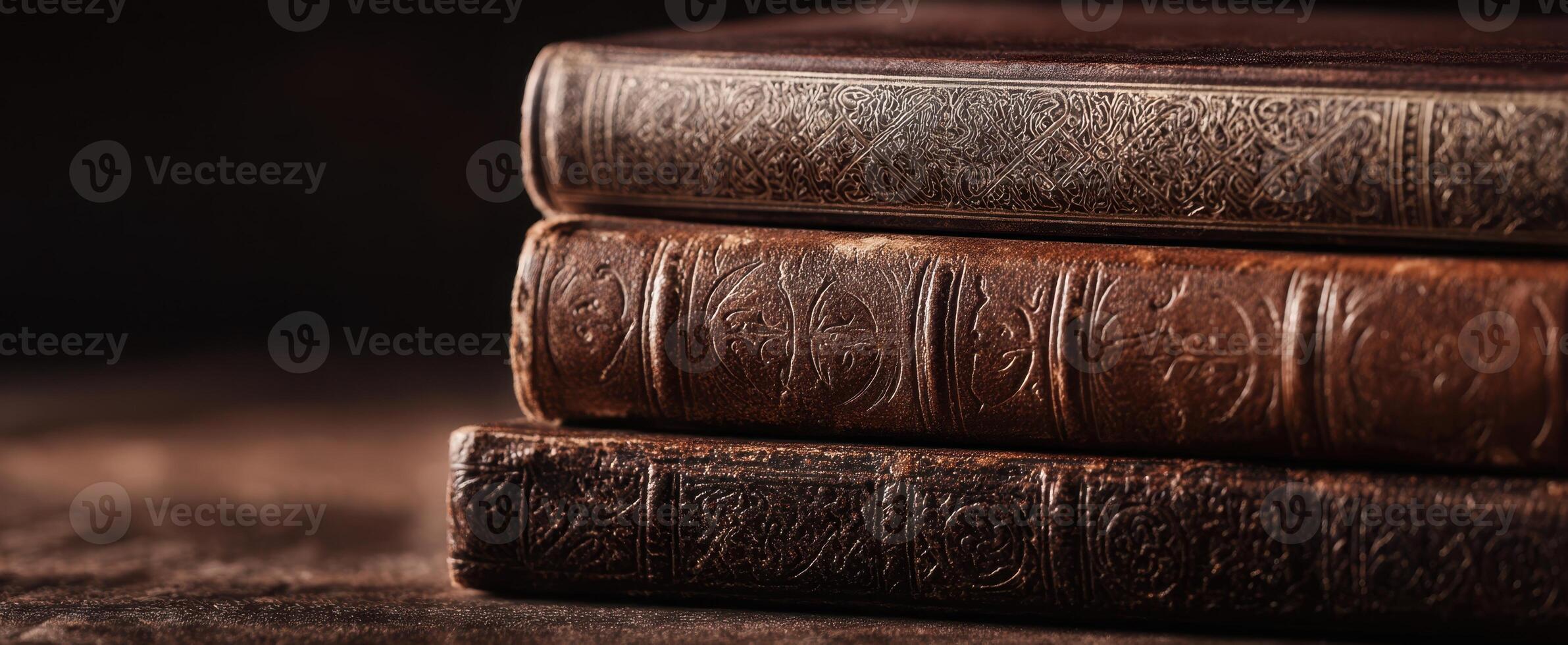 The aged leather-bound books resting elegantly on a wooden surface. photo