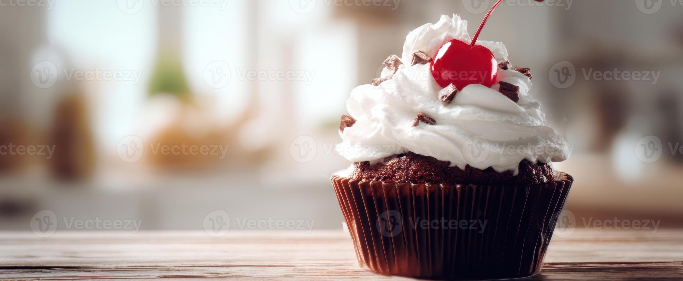 The decadent chocolate cupcake topped with fluffy whipped cream and cherry. photo