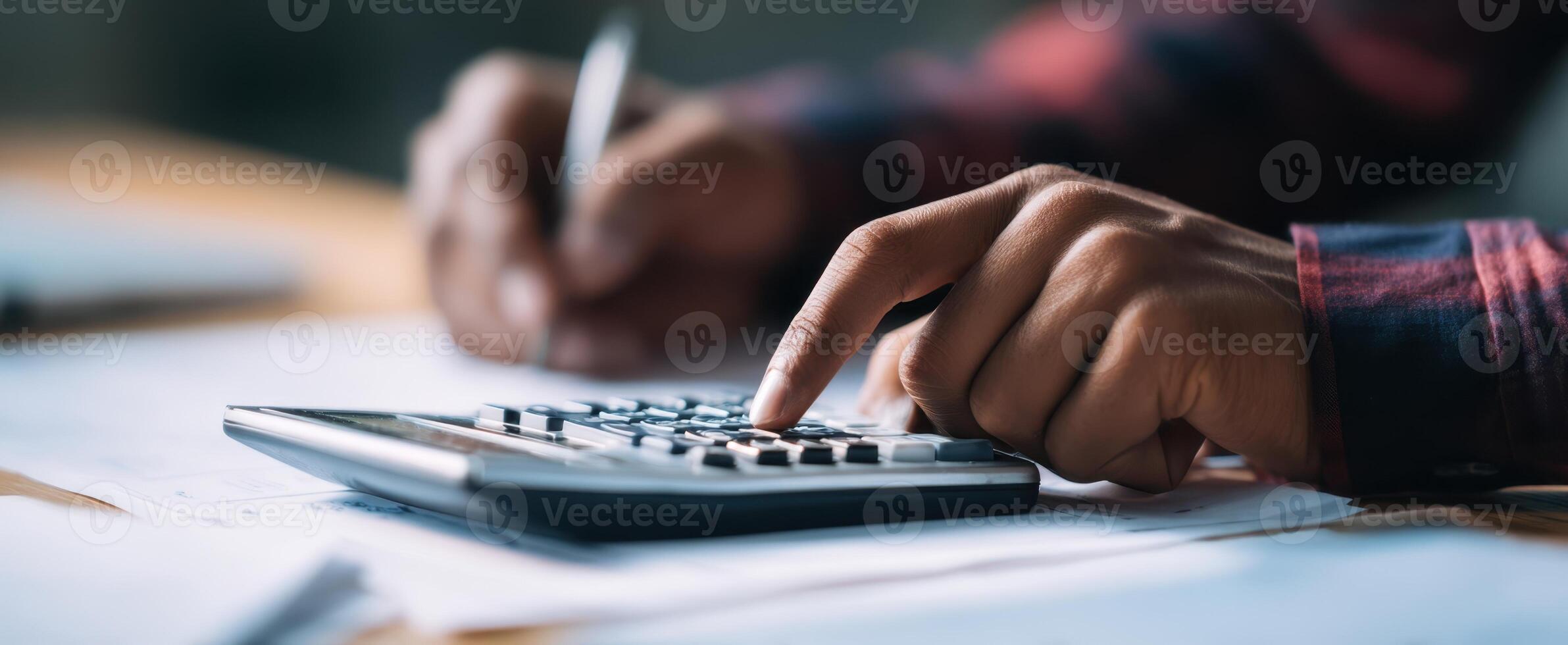 The focused hands using a calculator amidst financial paperwork and notes. photo