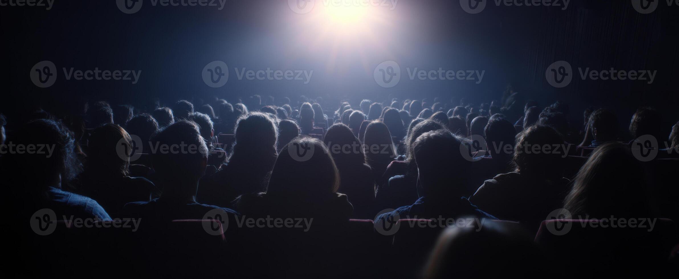 The audience captivated by a cinematic experience in a darkened theater setting. photo
