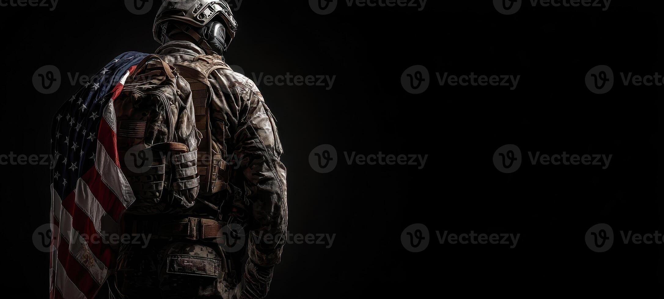 The soldier proudly wearing the American flag in a dark, moody setting. photo