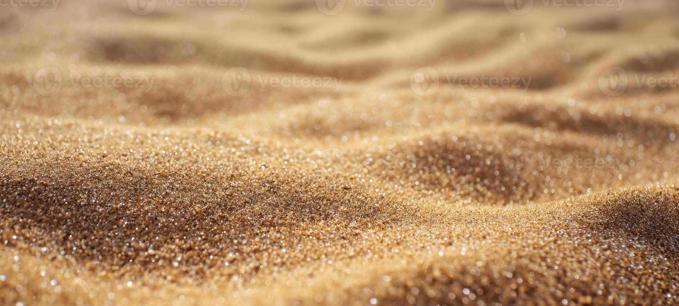 The shimmering golden sand with gentle waves and sparkling texture photo