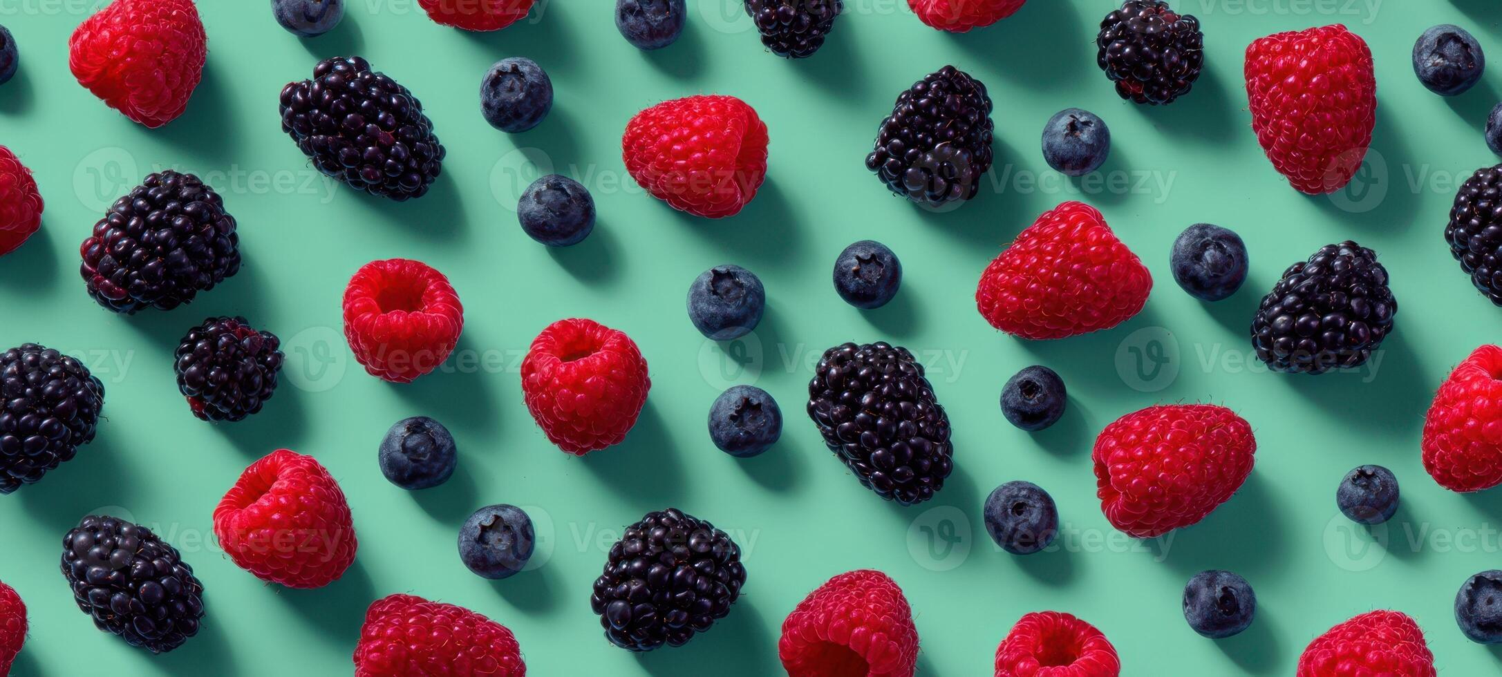 The vibrant arrangement of assorted berries on a teal background. photo