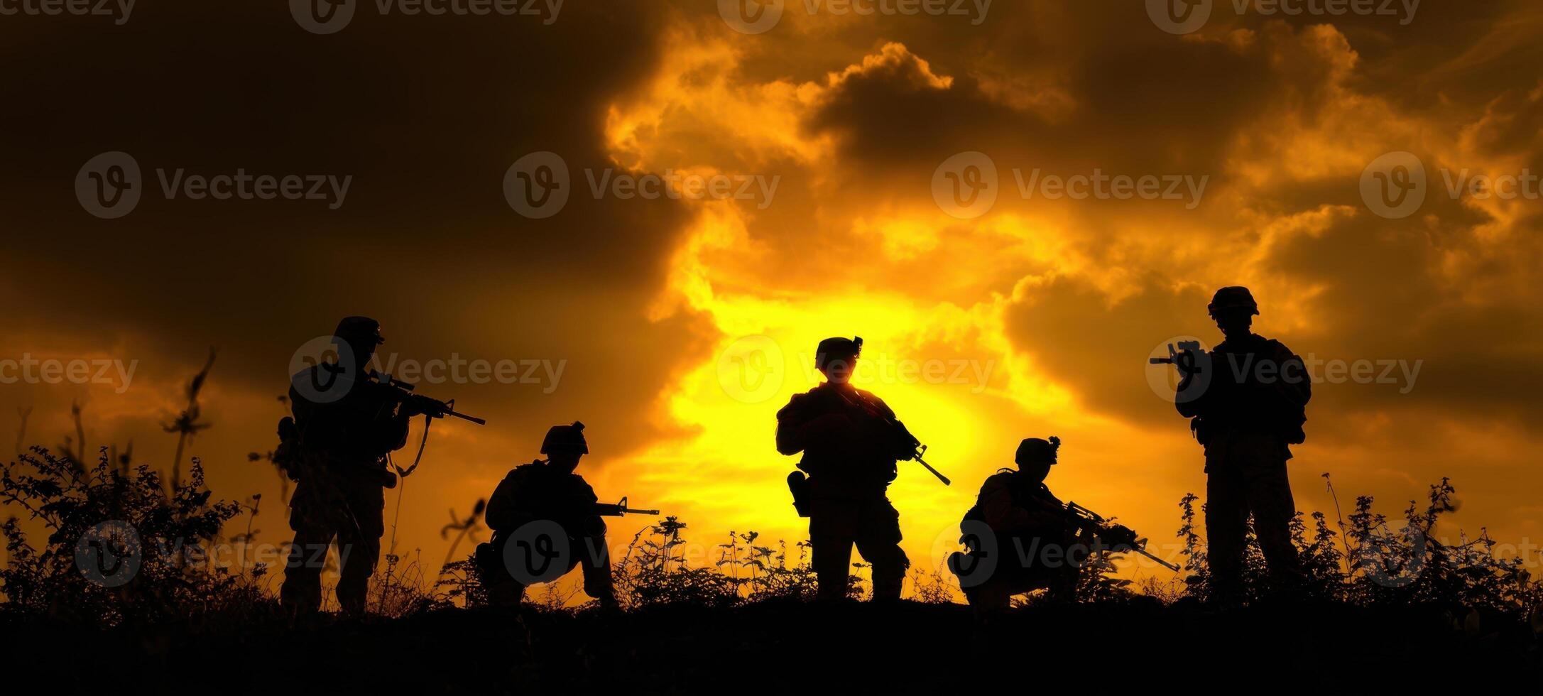 The soldiers striking a heroic pose against a dramatic sunset background. photo