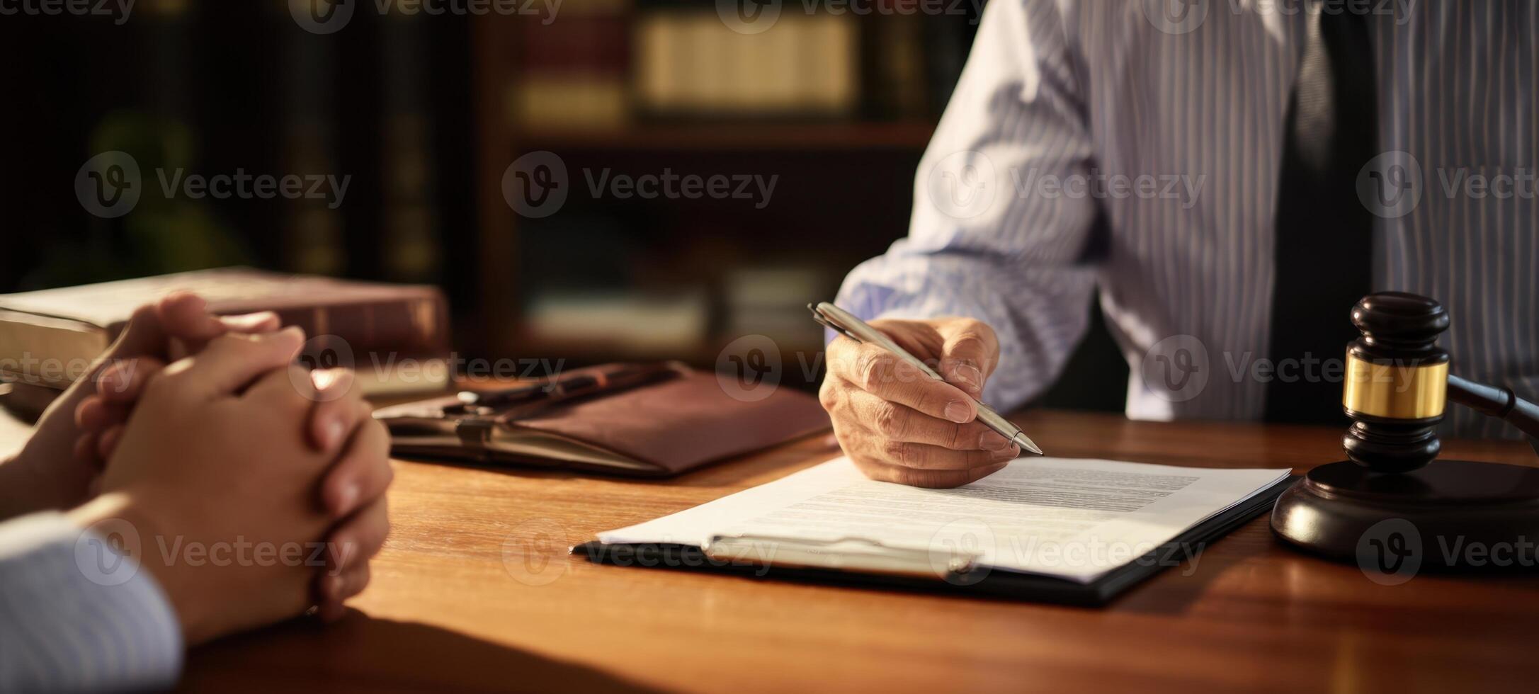 The lawyer signing documents during a legal consultation with a client. photo