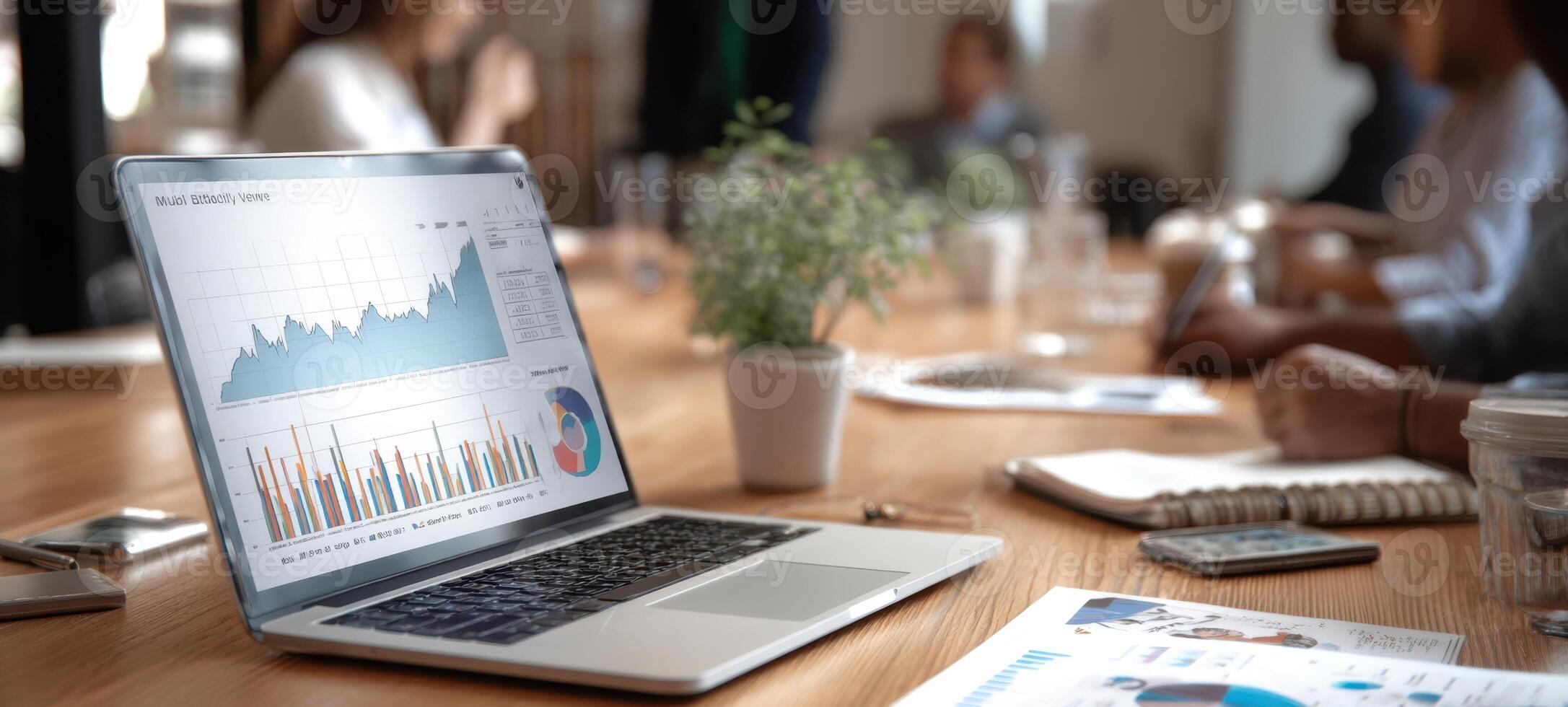 The laptop displaying data analytics in a modern office meeting environment. photo