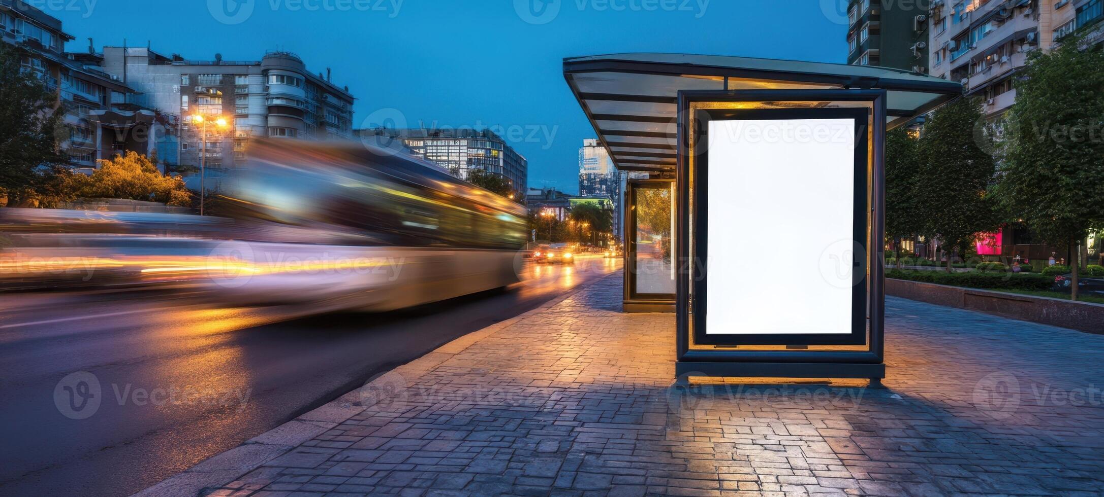The illuminated bus stop with a blank advertising space at twilight. photo
