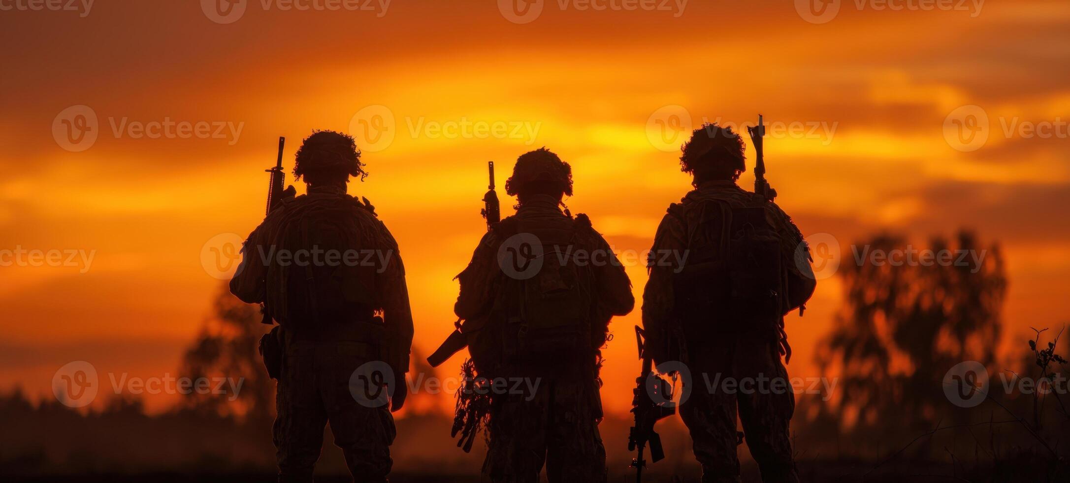 The silhouettes of soldiers standing together against a vibrant sunset backdrop. photo