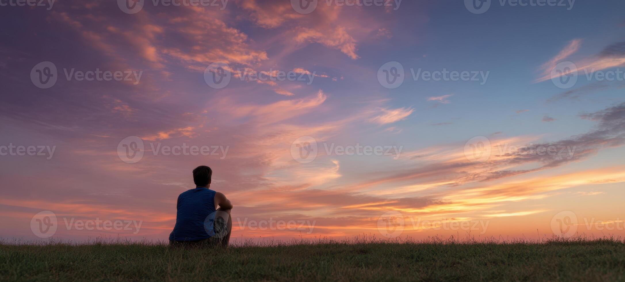 The Person Sitting Alone Enjoying a Serene Sunset in Nature photo