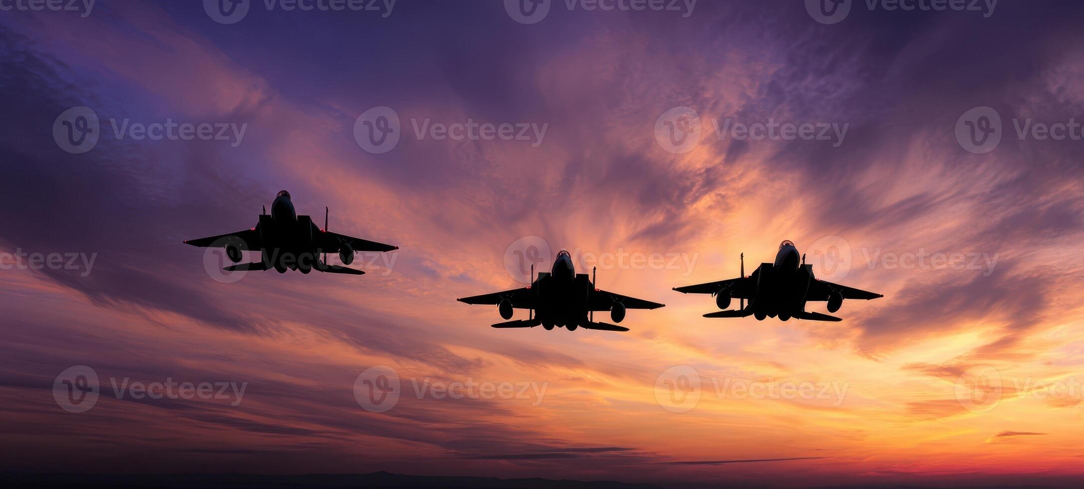 The silhouette of military fighter jets flying through a colorful sunset sky. photo