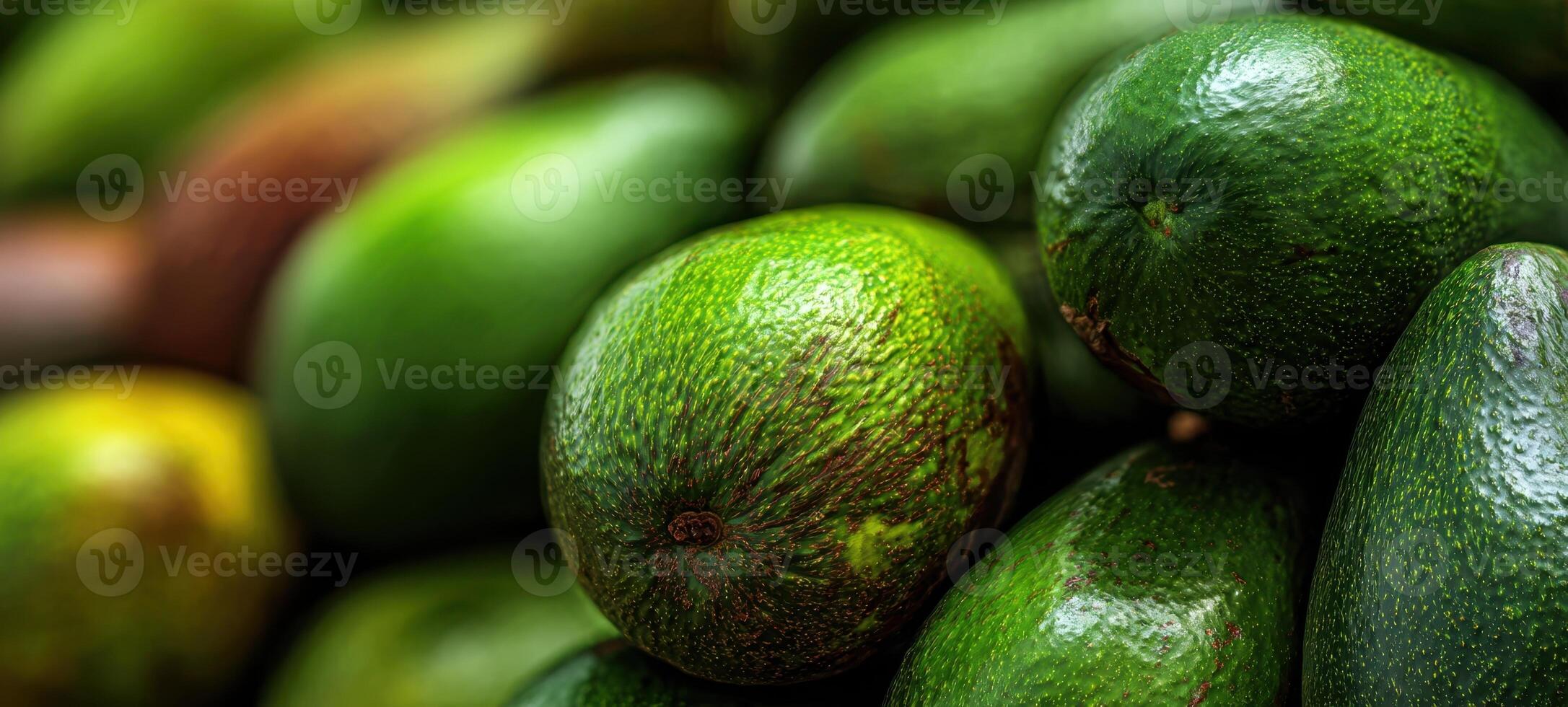 The vibrant green avocados stacked in a fresh produce display. photo