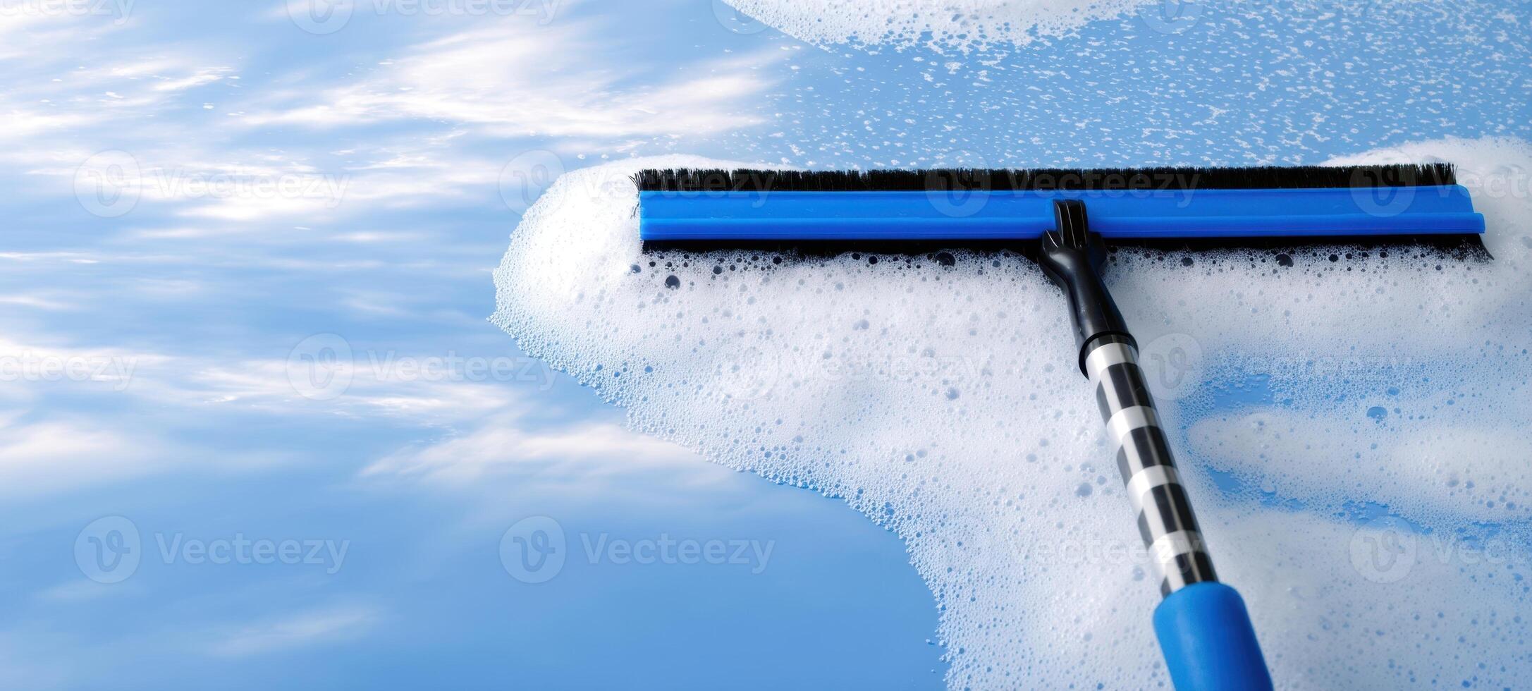 The squeegee gliding over bubbly surface for effortless cleaning results. photo