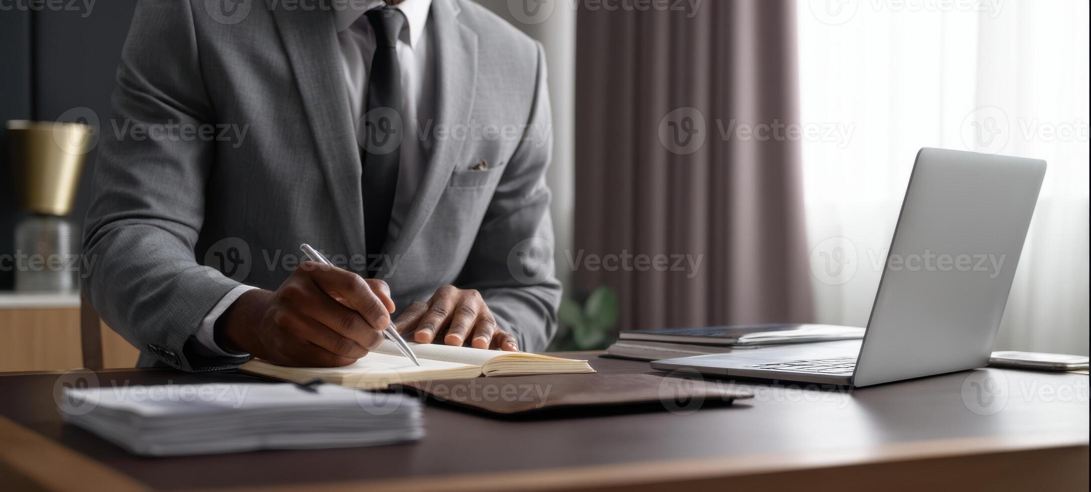 The businessman writing in a notebook at a stylish modern office desk. photo