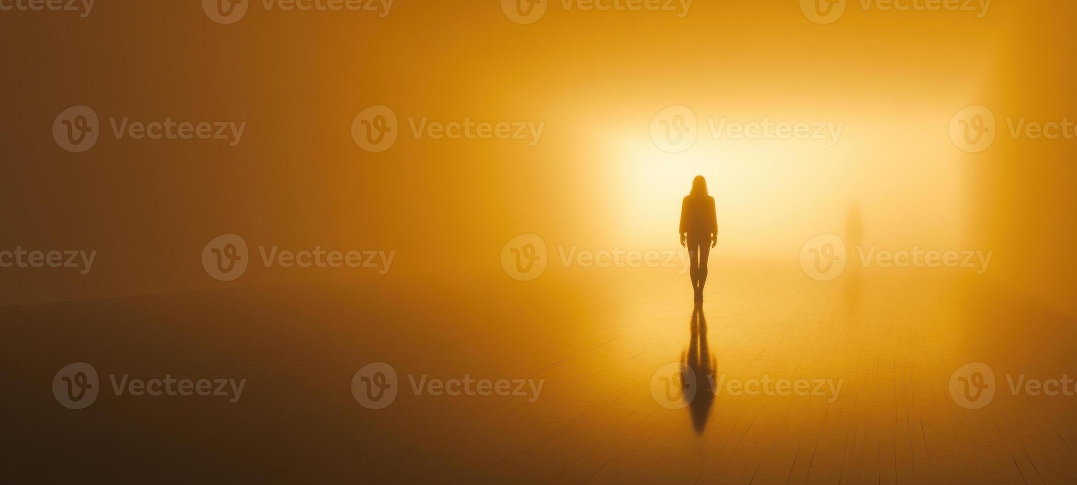 The silhouette of a person walking through a surreal foggy landscape. photo